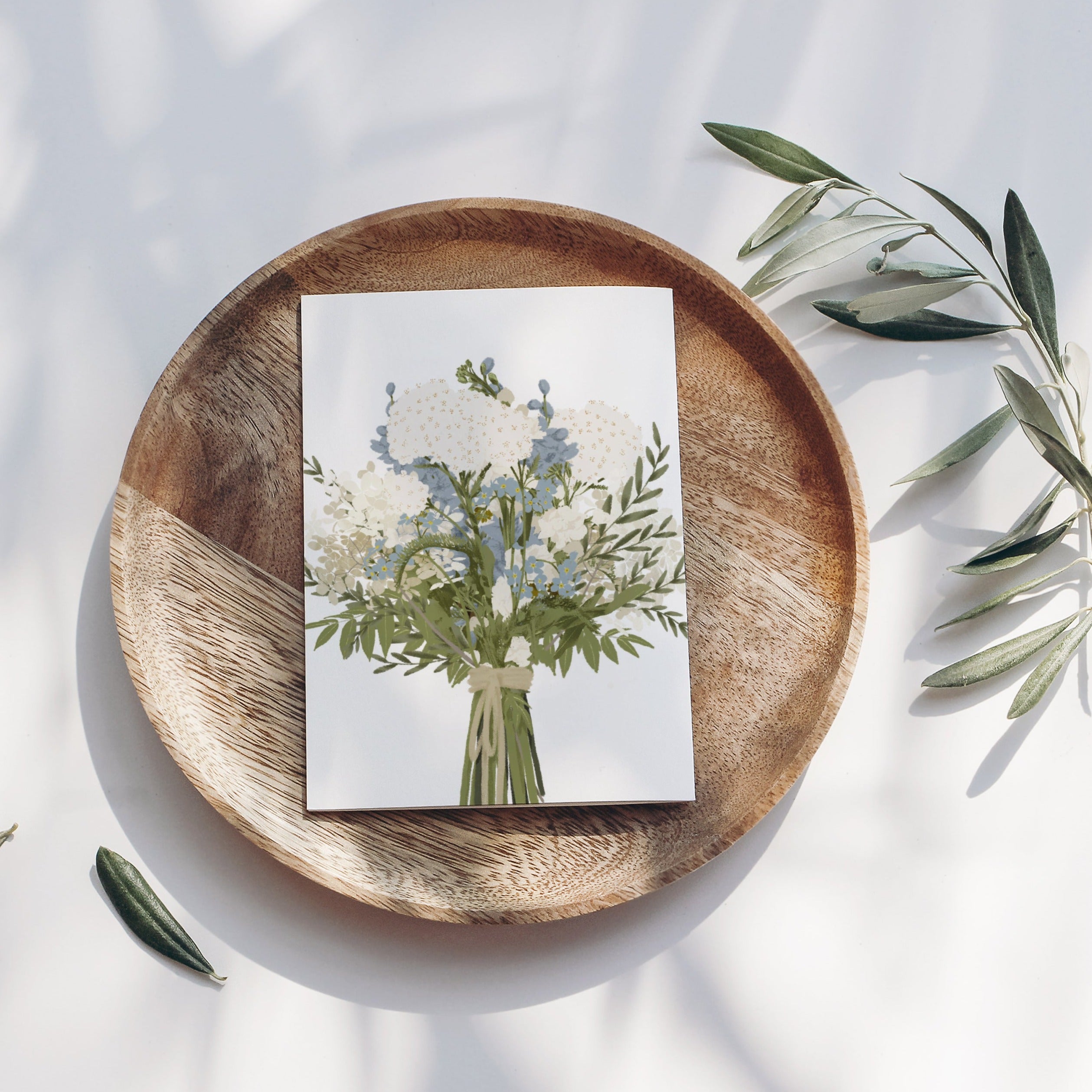 Illustration eines Blumenstraußes auf einer Holzplatte mit Olivenzweigen auf weißem Hintergrund.