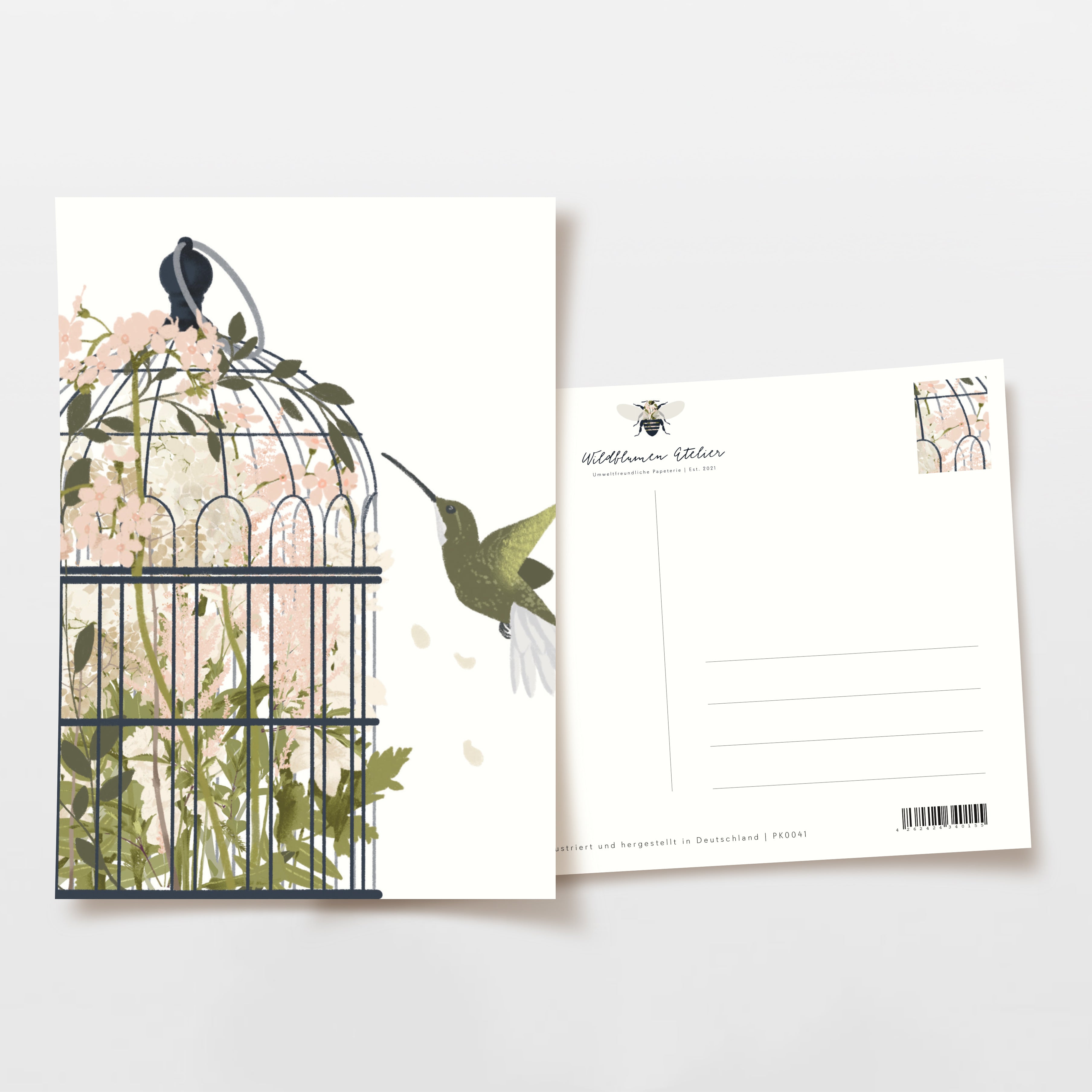 Postkarte mit einem Kolibri, der vor einem Vogelkäfig mit Blumen schwebt; Rückseite zeigt Adresslinien.