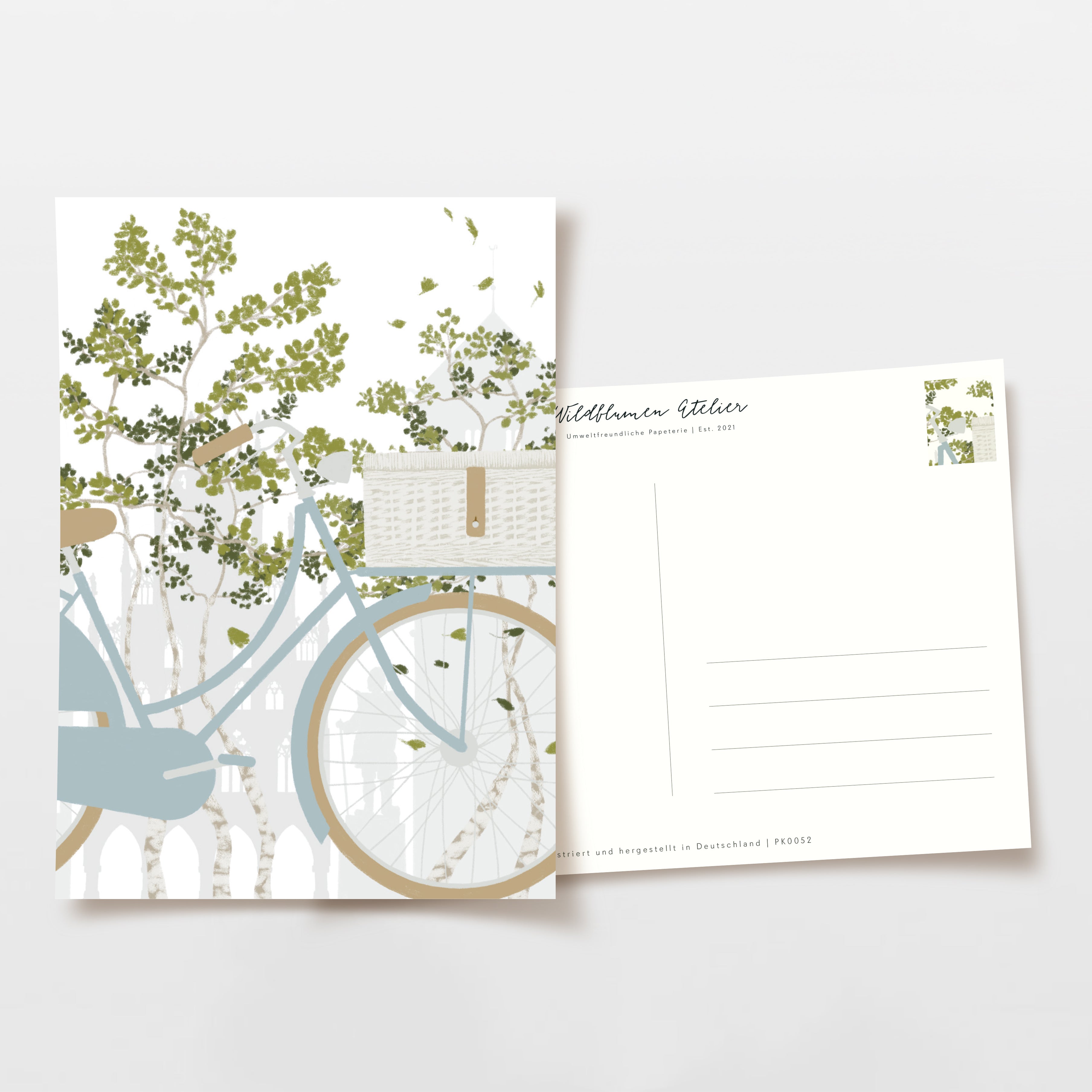 Postkarte mit minimalistischem Fahrrad- und Baum-Design neben der Rückseite mit Adressfeldern und Briefmarkenbereich.