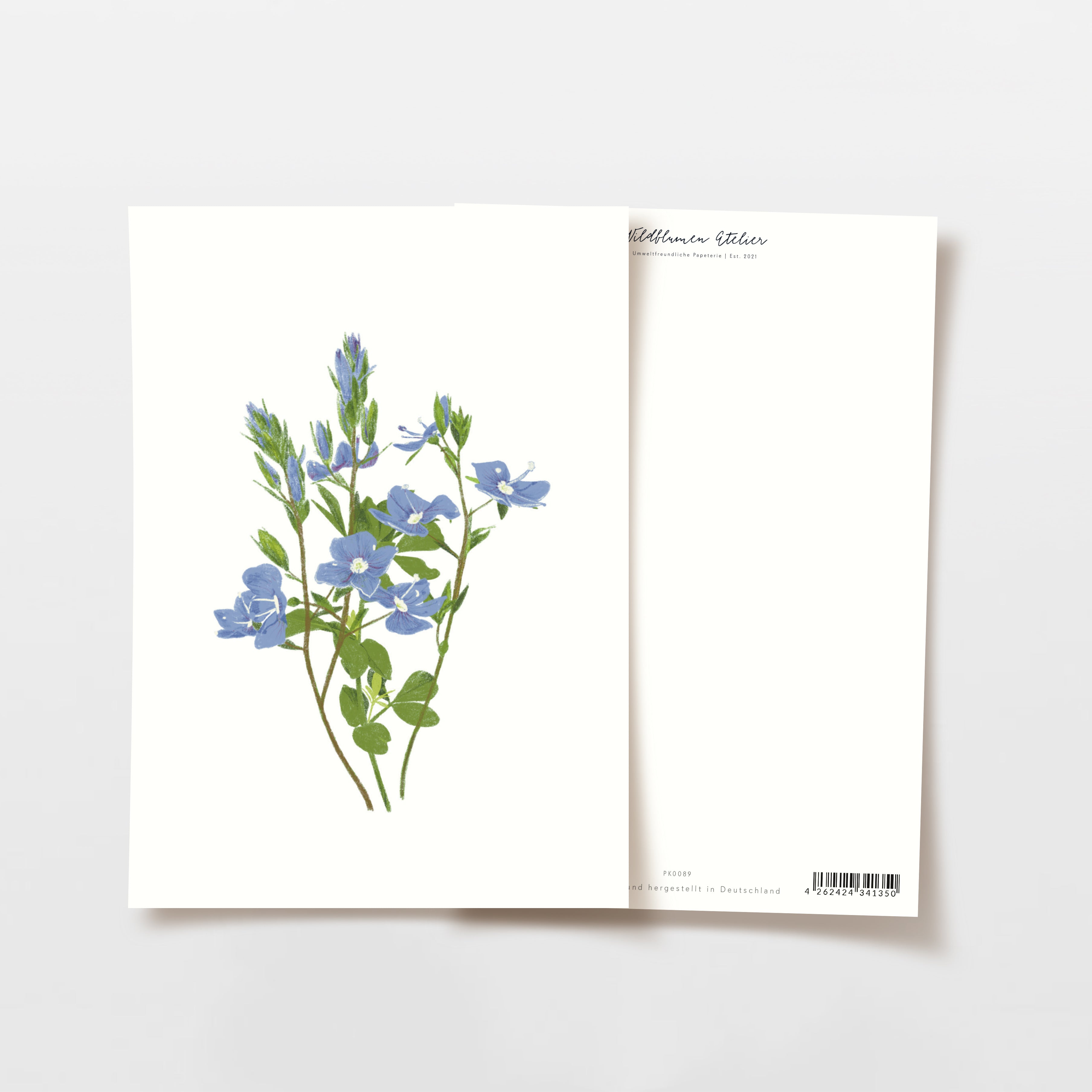 Weiße Grußkarte mit blauen Blumenillustrationen auf der Vorderseite, im Hintergrund eine zweite, teils verdeckte Karte.