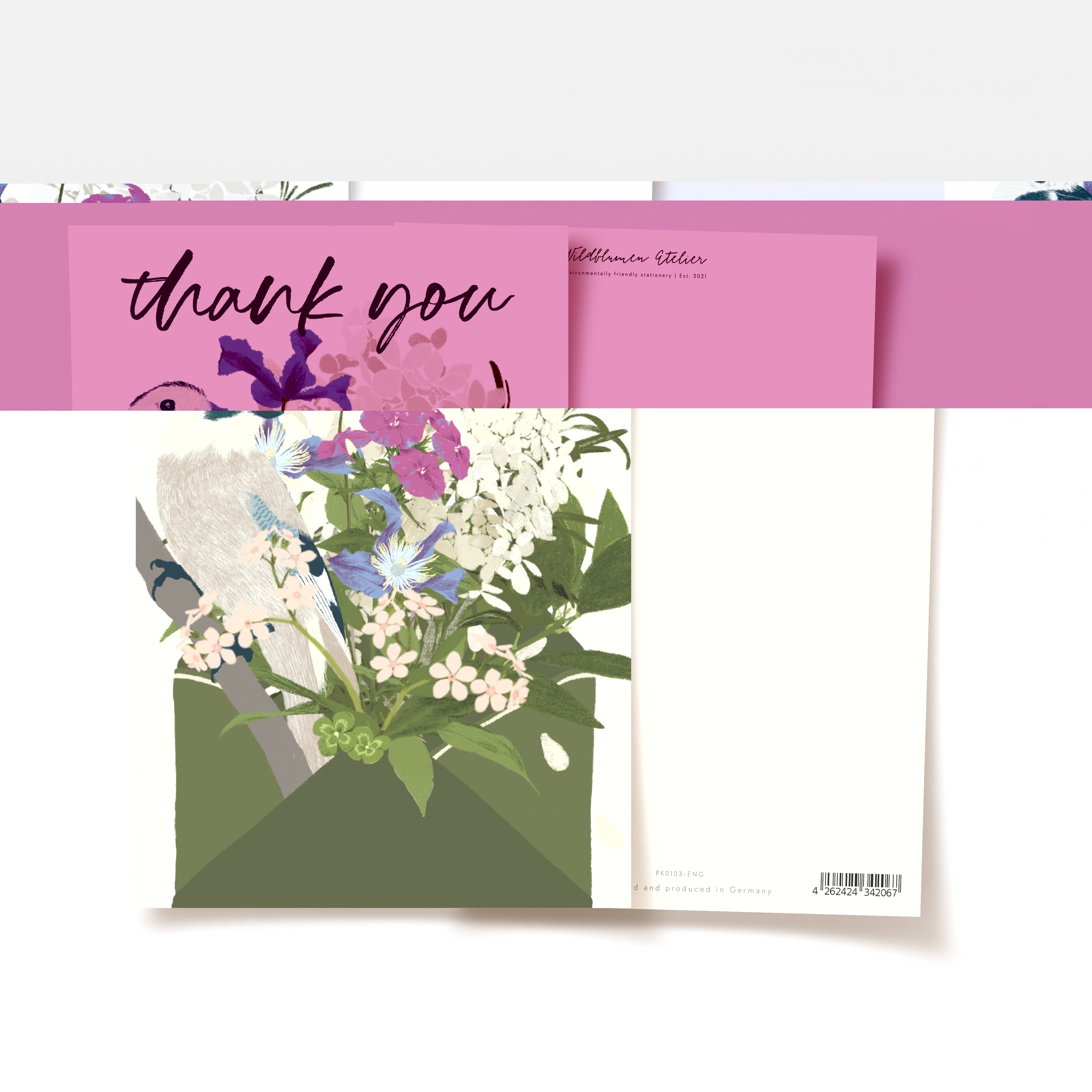 Eine Grußkarte mit einem floralen Design, das verschiedene bunte Blumen und grüne Blätter zeigt. Die Karte ist teilweise geöffnet und enthüllt eine "Danke"-Nachricht auf einem rosa Hintergrund. Auf der Rückseite befinden sich ein Barcode und die Produktangaben.