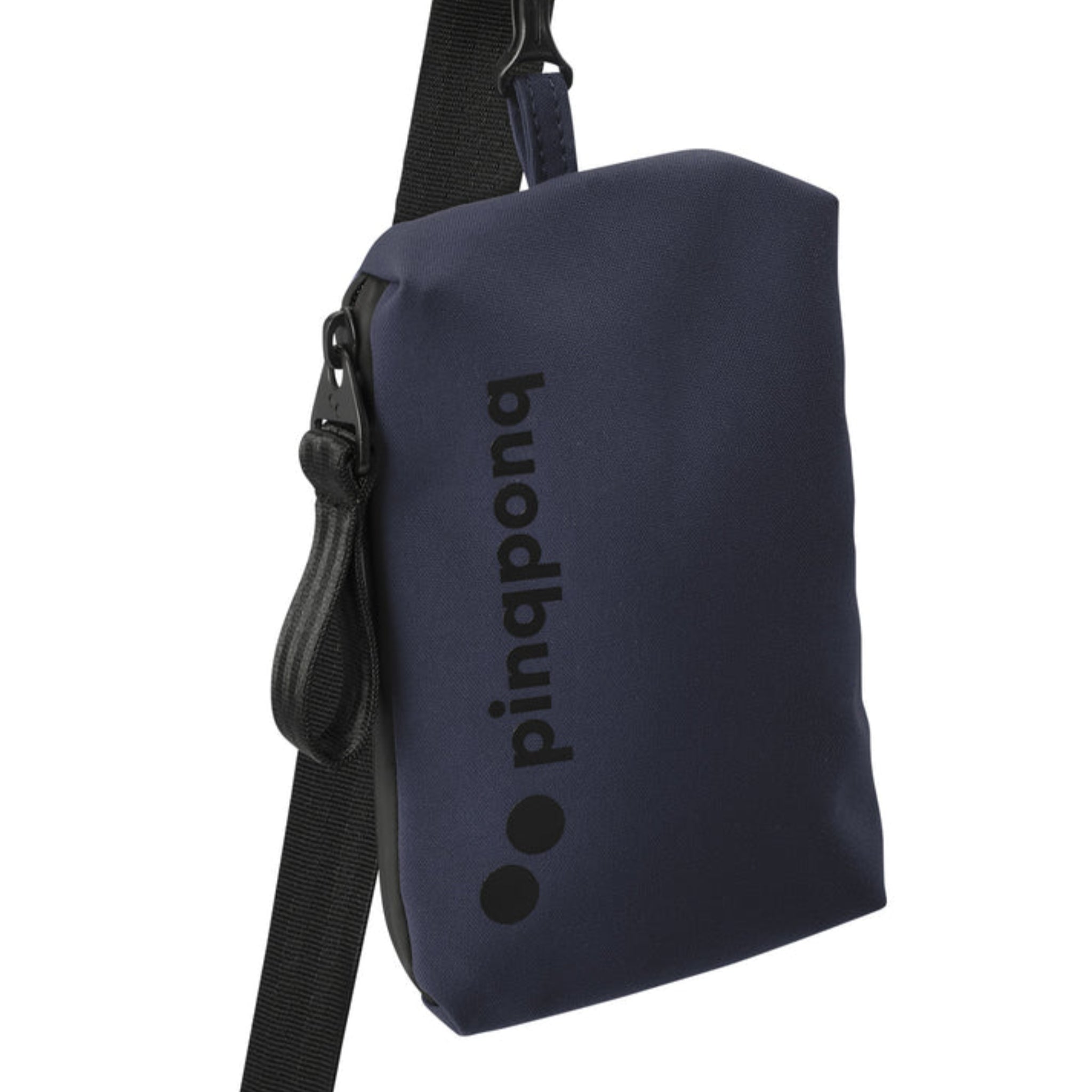 Eine kleine, marineblaue Umhängetasche mit einem schwarzen, verstellbaren Riemen und dem Markennamen pinqponq, der vertikal in schwarzen Buchstaben auf die Vorderseite gedruckt ist.