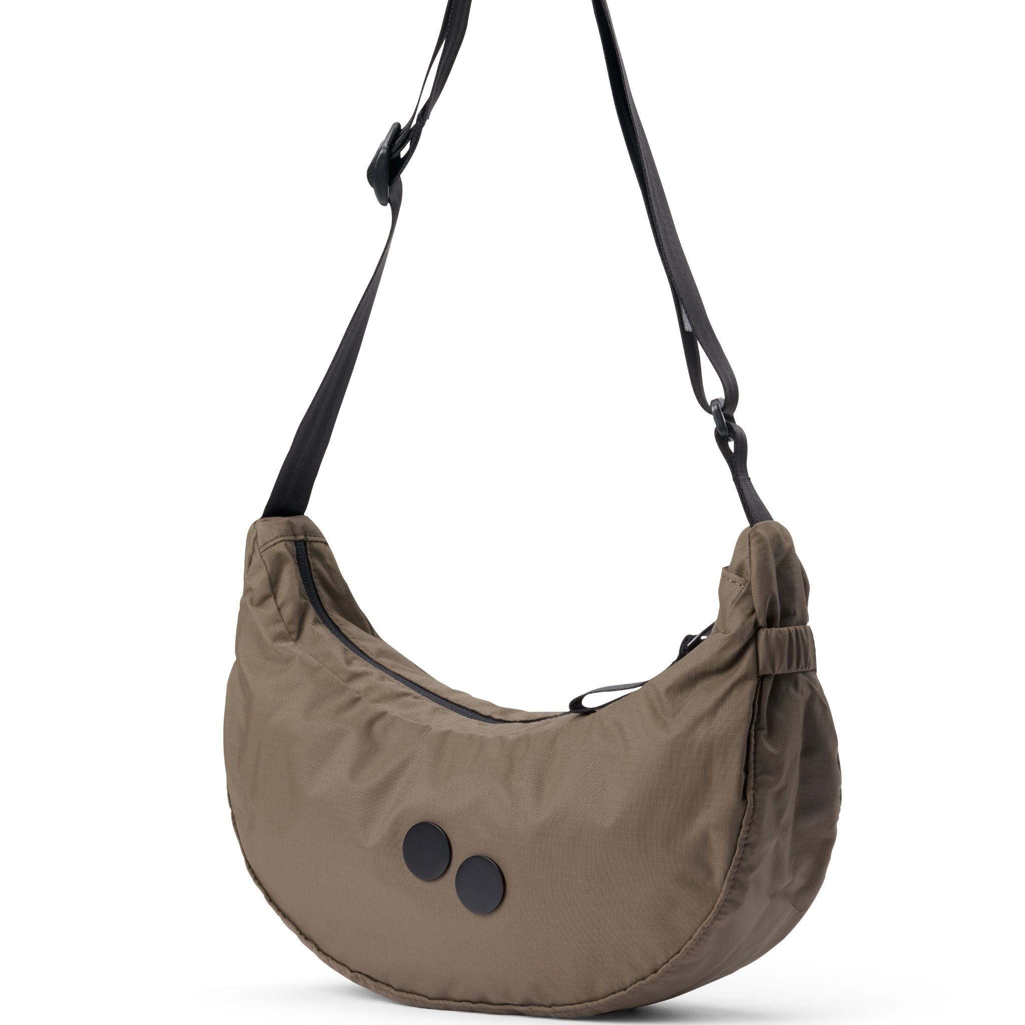 Beige Umhängetasche aus Stoff mit zwei schwarzen runden Applikationen und verstellbarem schwarzen Riemen.