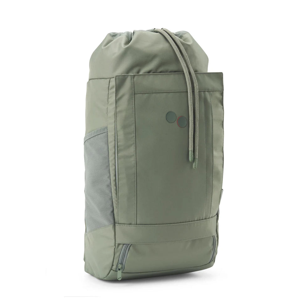 Ein salbeigrüner Rucksack mit Kordelzug, seitlichen Netztaschen, einem Bodenfach mit Reißverschluss und zwei kleinen kreisförmigen Akzenten auf der Vorderseite. Die Tasche steht aufrecht auf einem schlichten weißen Hintergrund.