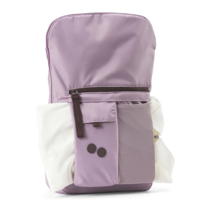 Ein lavendelfarbener Rucksack mit einer vorderen Reißverschlusstasche, einer Netztasche, zwei schwarzen Knöpfen und weißem Stoff in den Seitentaschen steht aufrecht auf weißem Hintergrund.