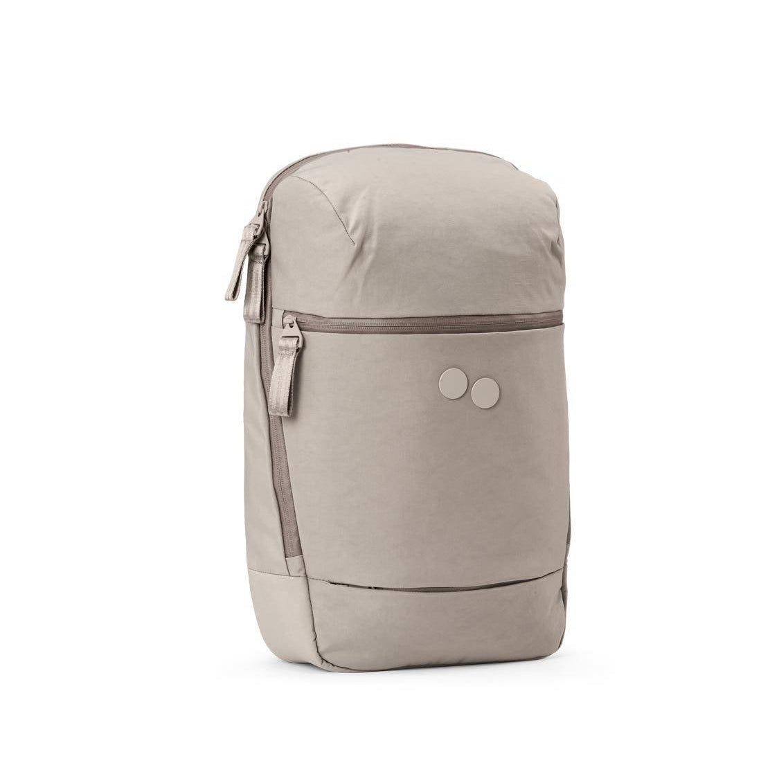 Ein hellbeiger Rucksack mit einer Reißverschlusstasche auf der Vorderseite, einfachem Design und zwei kleinen kreisförmigen Logopunkten auf der Vorderseite. Der Rucksack hat einen minimalistischen Look und ist vor einem weißen Hintergrund fotografiert.