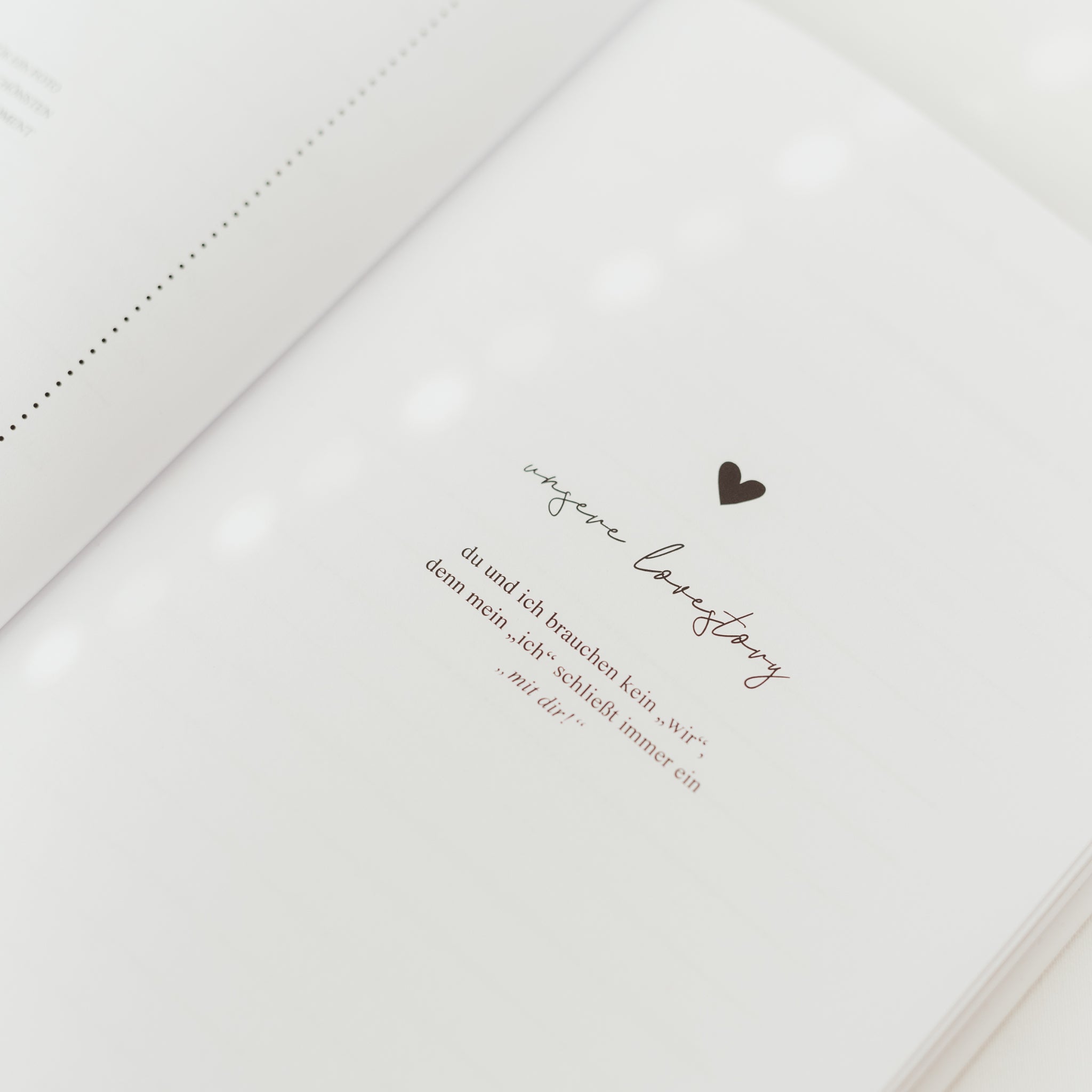 Offenes Buch mit Text und kleinem Herzsymbol auf der Seite.