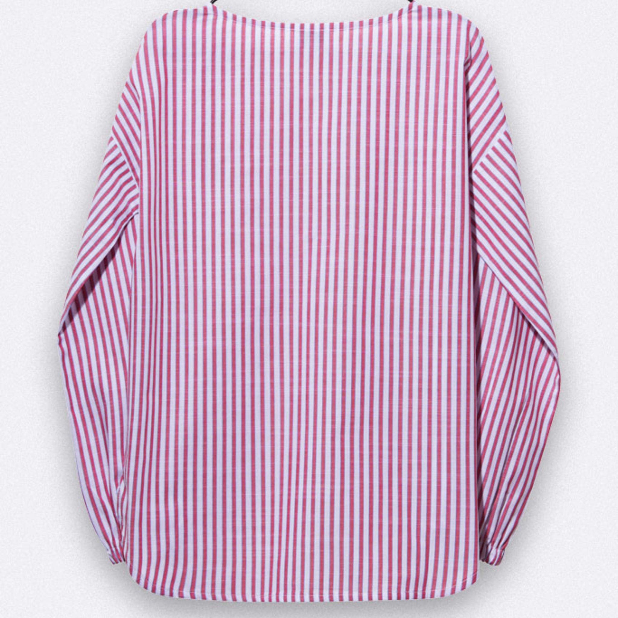 Ein langärmeliges Hemd mit vertikalen rosa und weißen Streifen, mit weiten Ärmeln und einer lockeren Passform, die sich vor einem hellgrauen Hintergrund abzeichnet.