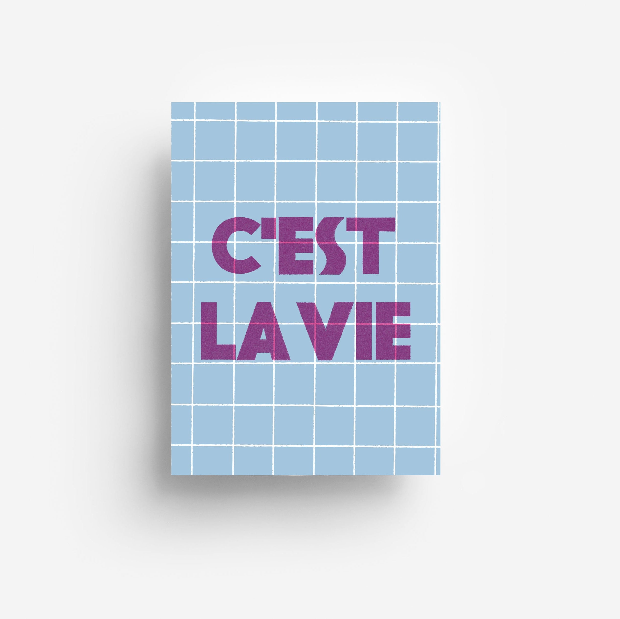 Eine Karte mit einem hellblauen Gittermuster und einem fetten violetten Text in der Mitte, der CEST LA VIE auf weißem Hintergrund lautet.