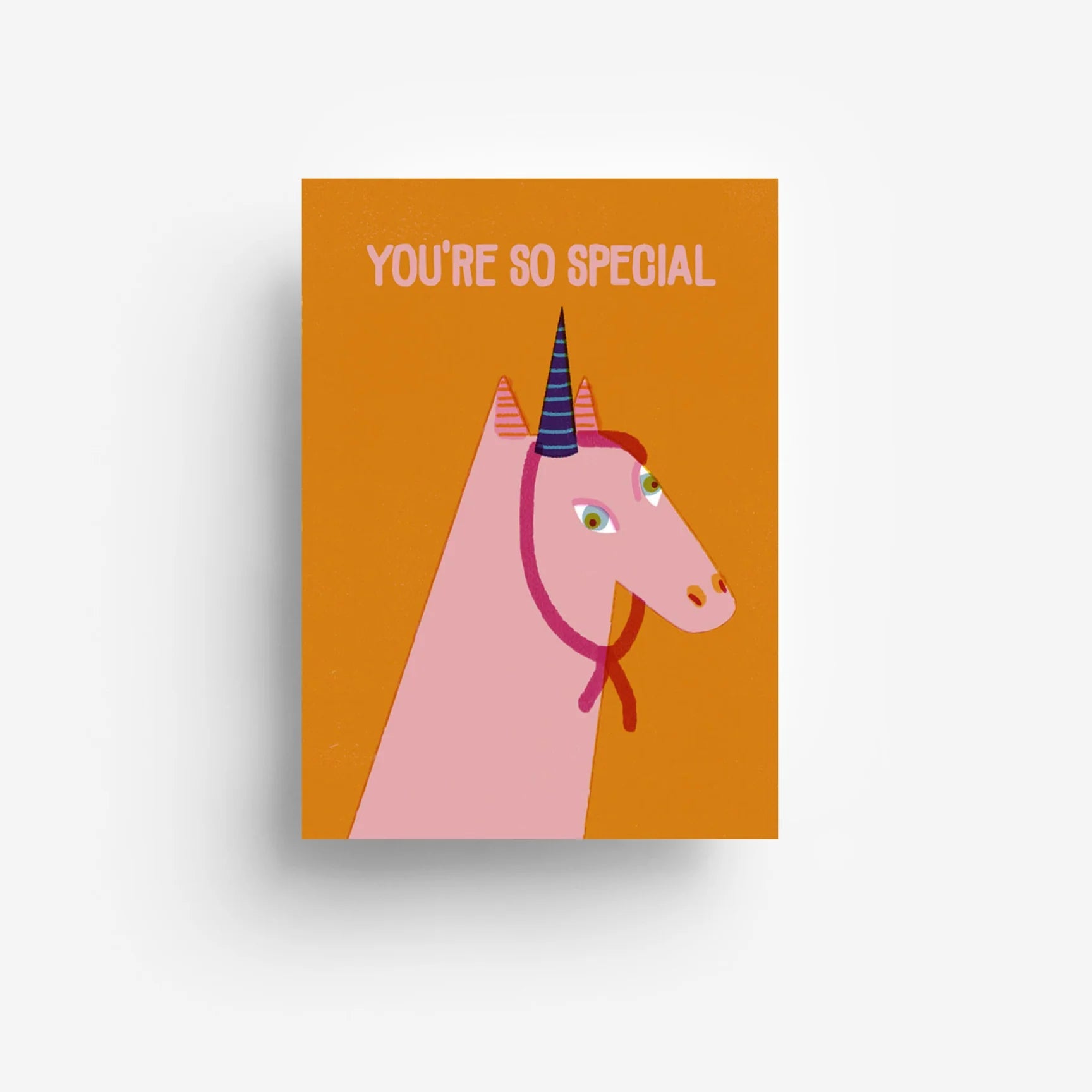 Grußkarte mit der Illustration eines rosa Einhorns mit regenbogenfarbigem Horn und rotem Zaumzeug auf orangefarbenem Hintergrund. Der Text am oberen Rand lautet "YOU'RE SO SPECIAL" in hellrosa Buchstaben.
