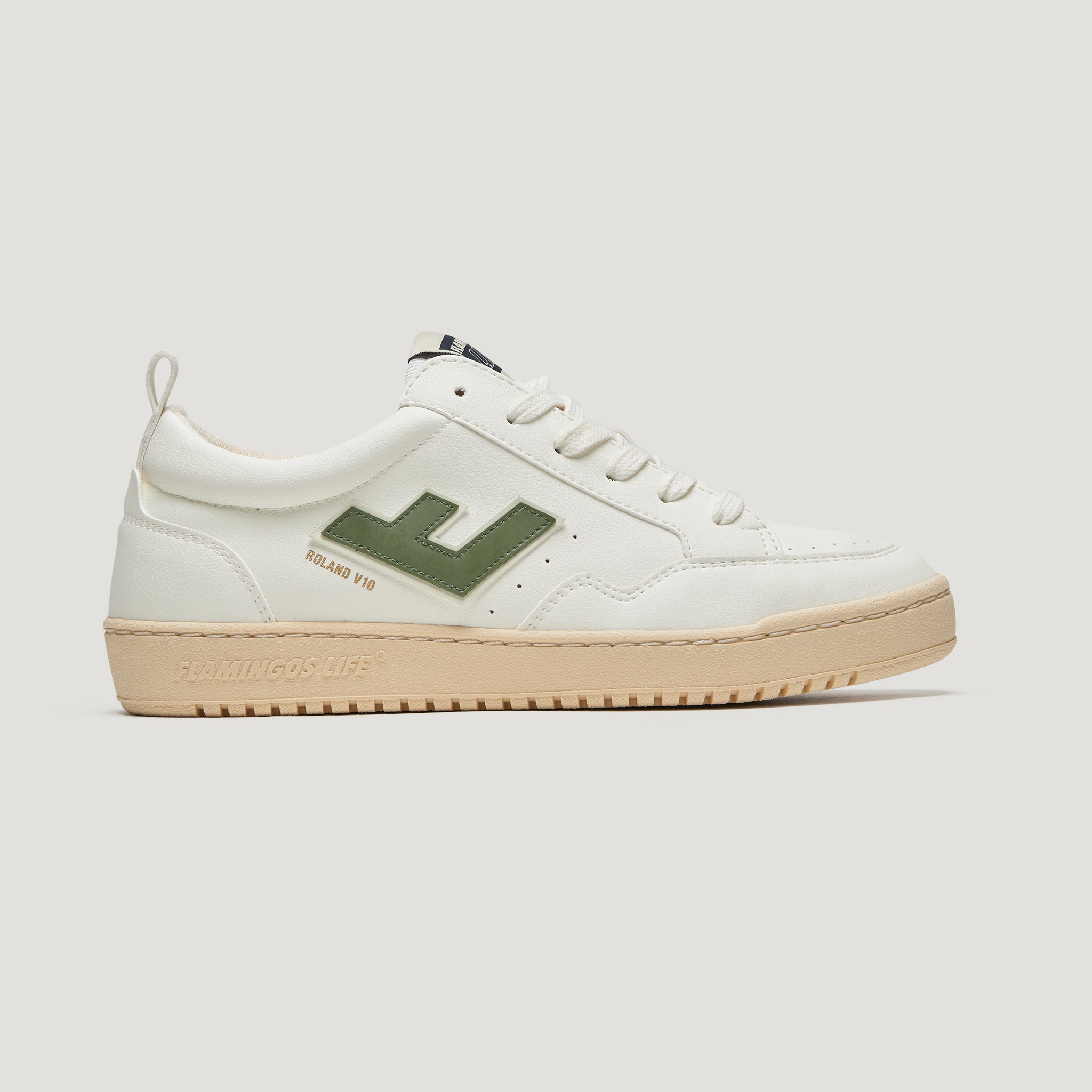 Weißer Sneaker mit grünem Detail an der Seite und heller Sohle, seitlich abgebildet.