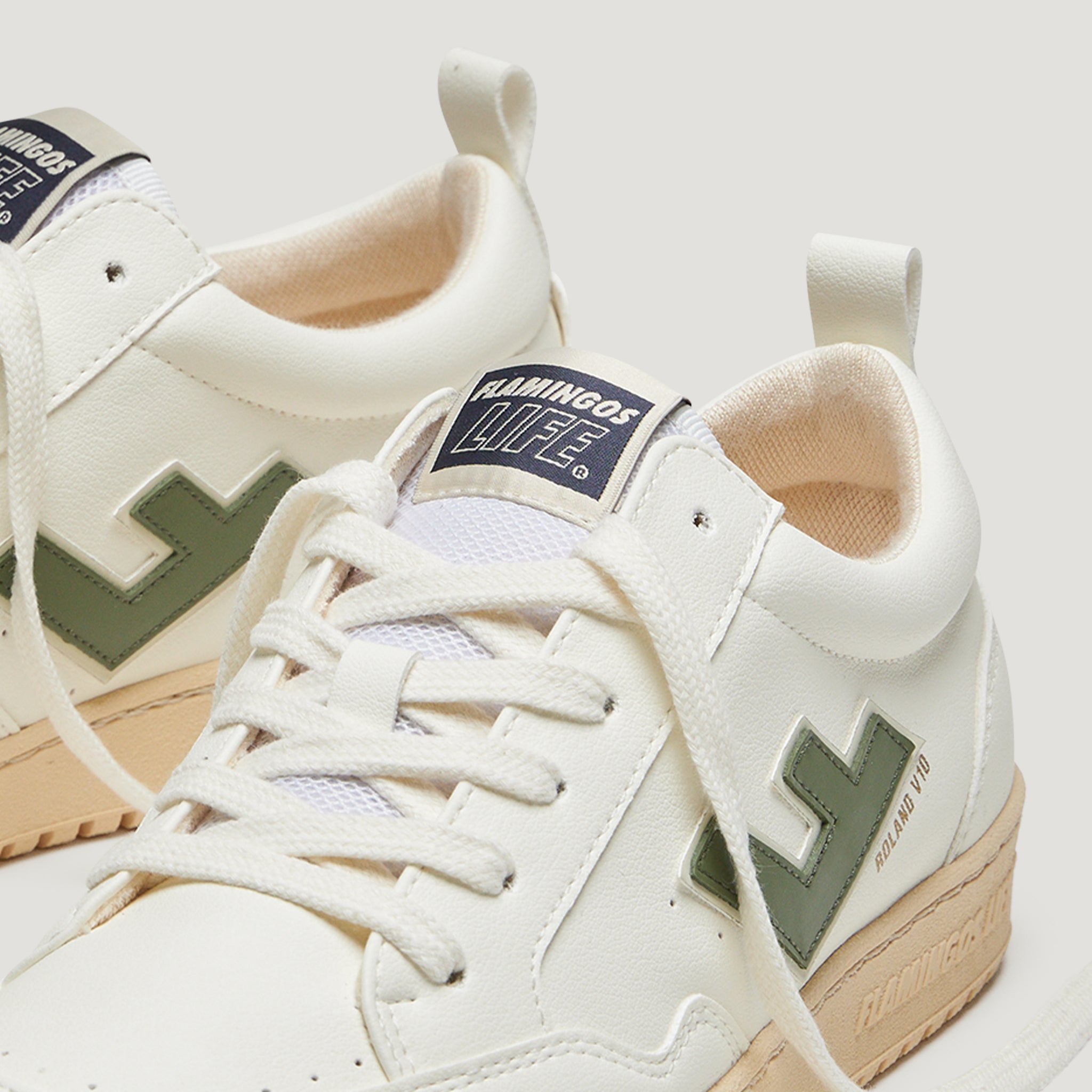 Weiße Sneaker mit beiger Sohle und grünem Logo, mit "FLAMINGOS LIFE" auf der Zunge.