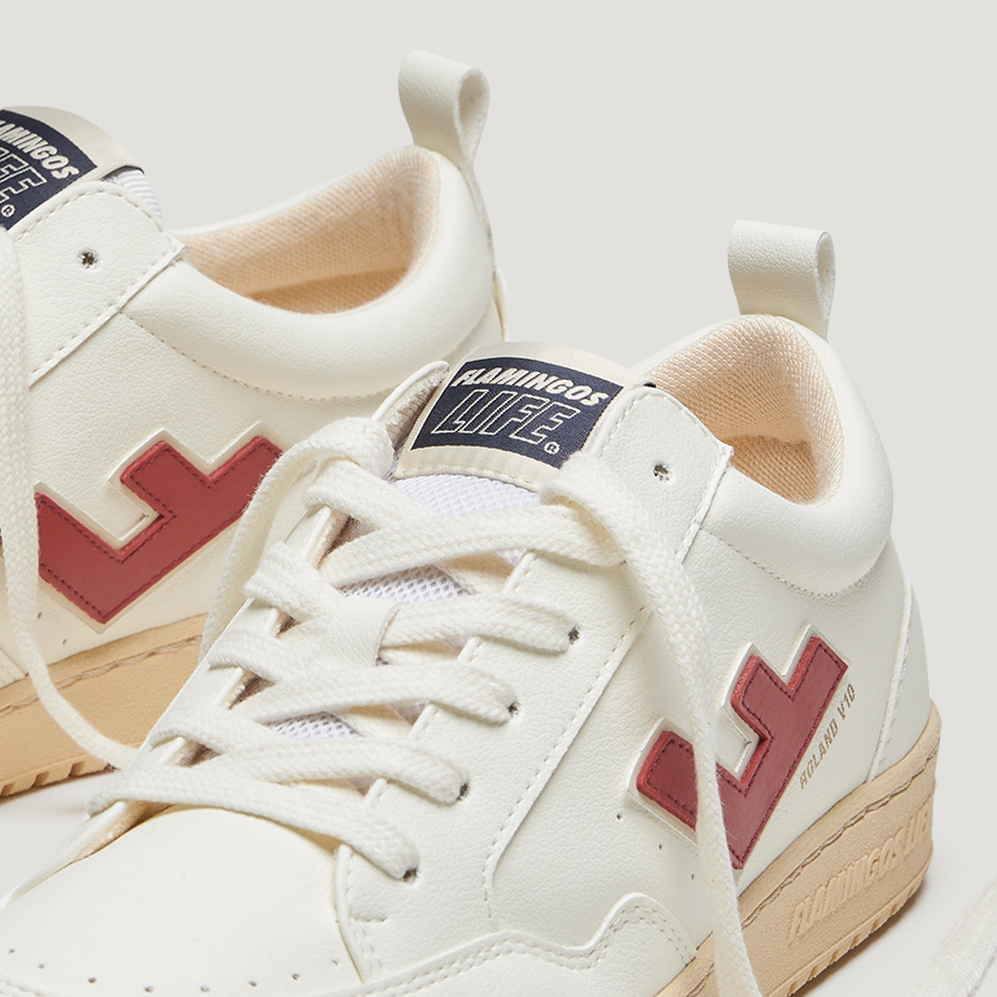 Weiße Sneaker mit roten Seitendetails und beige Sohlen, Marke "Flamingos Life" sichtbar auf der Zunge.
