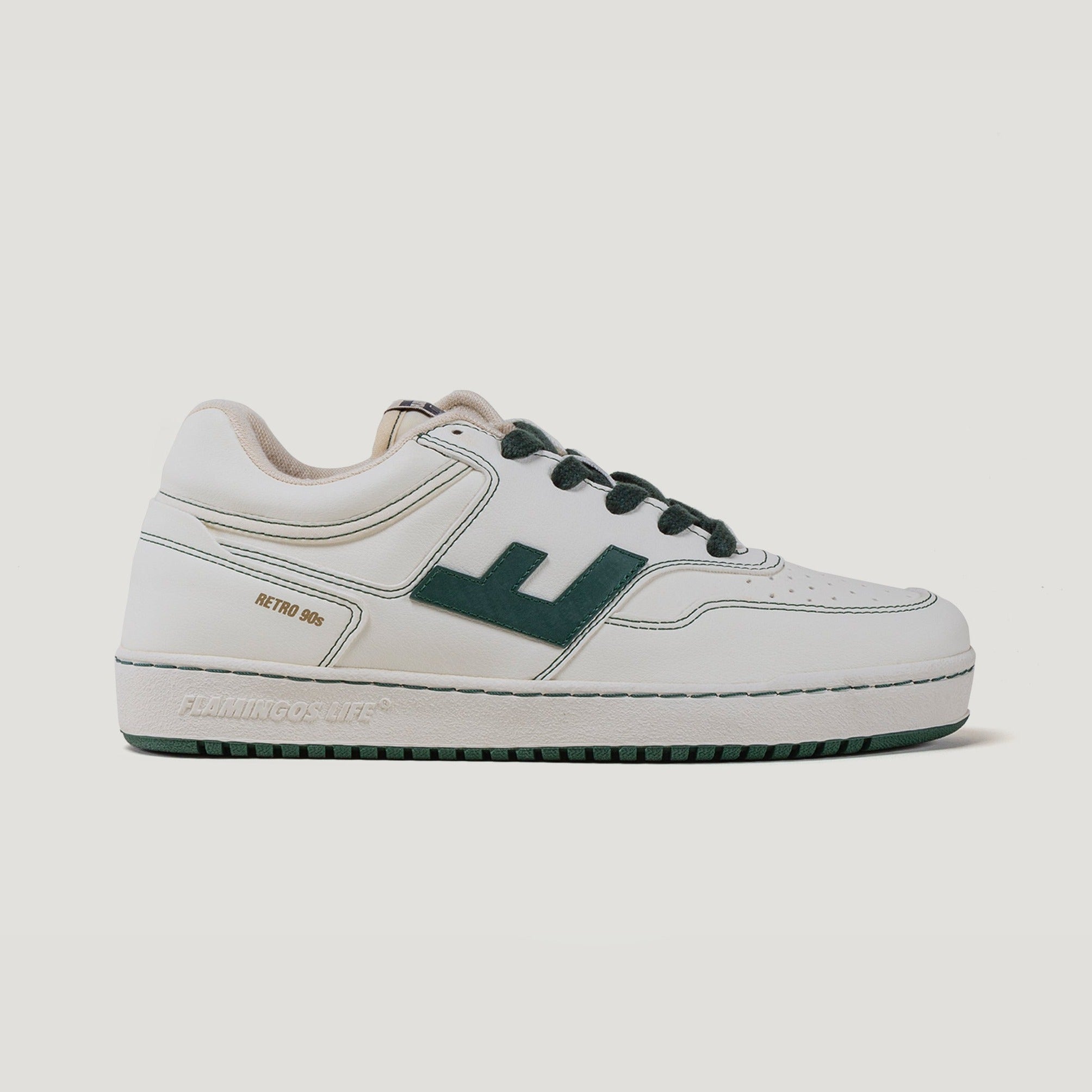 Weißer Turnschuh mit dunkelgrünen Details und einem großen "E" an der Seite, im Retro-Design der 90er Jahre.
