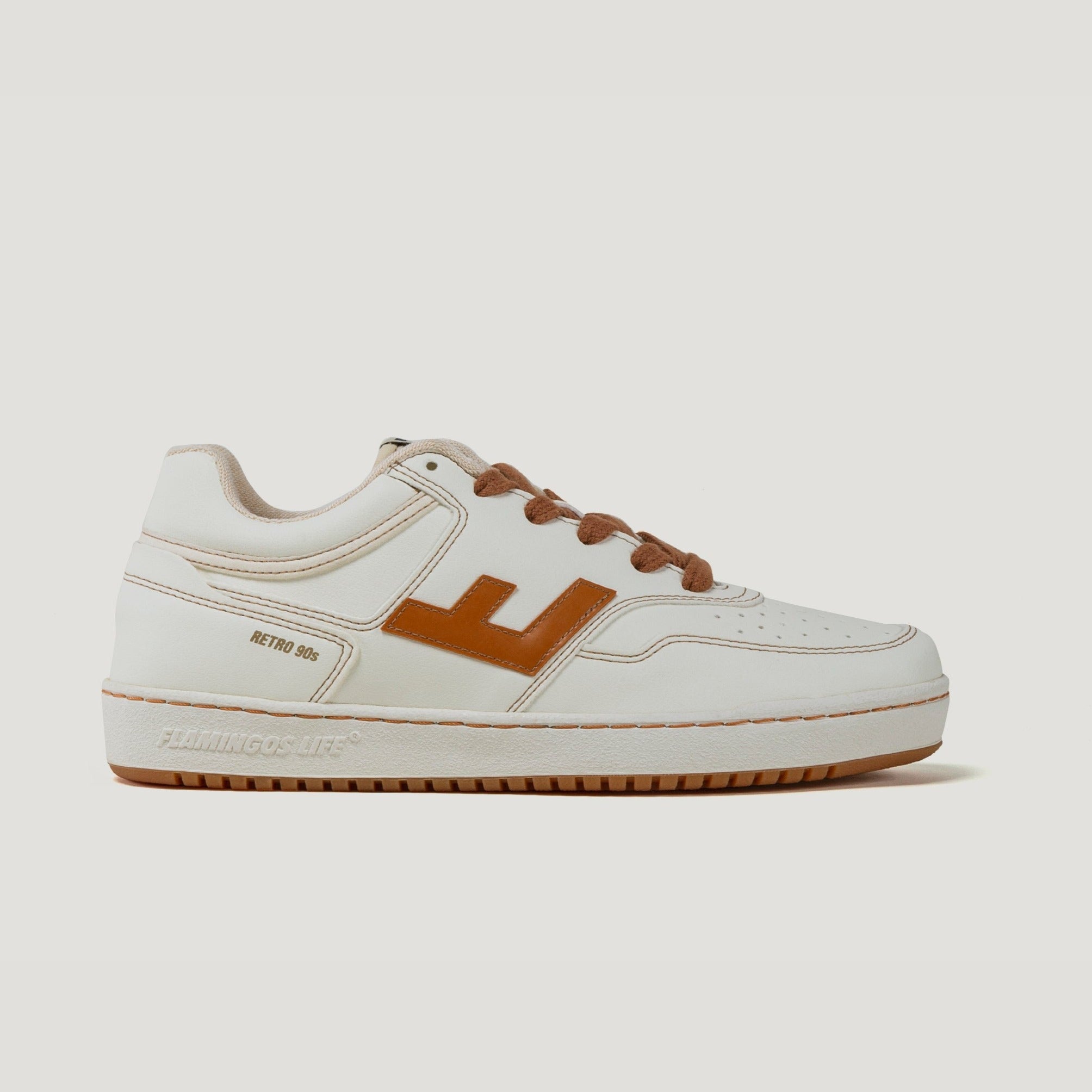 Weißer Sneaker mit braunen Akzenten und Schnürsenkeln, seitlich das Wort "RETRO 90s" und ein Logo.