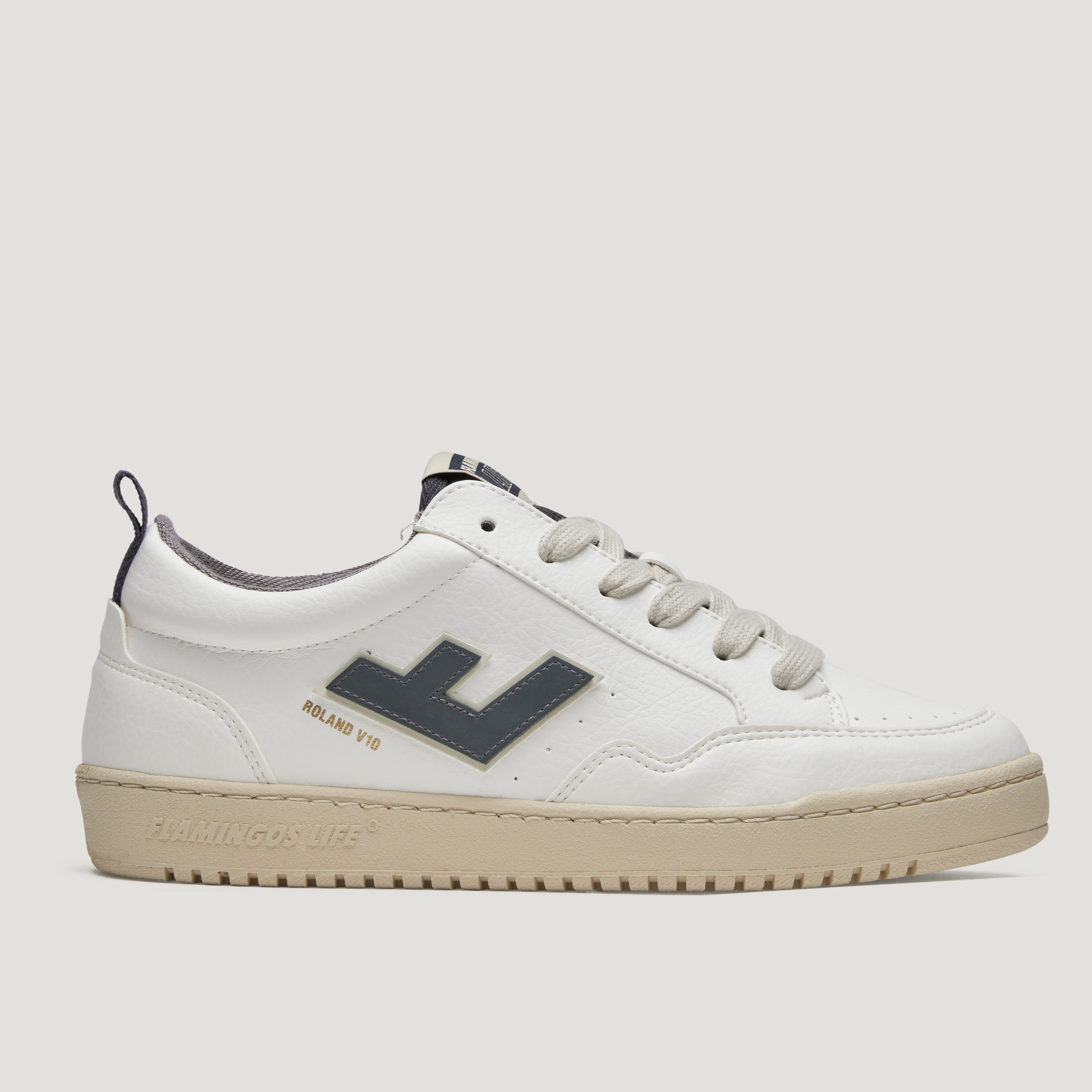 Weißer Sneaker mit dunkelblauem Logo und beiger Sohle, seitlich fotografiert.