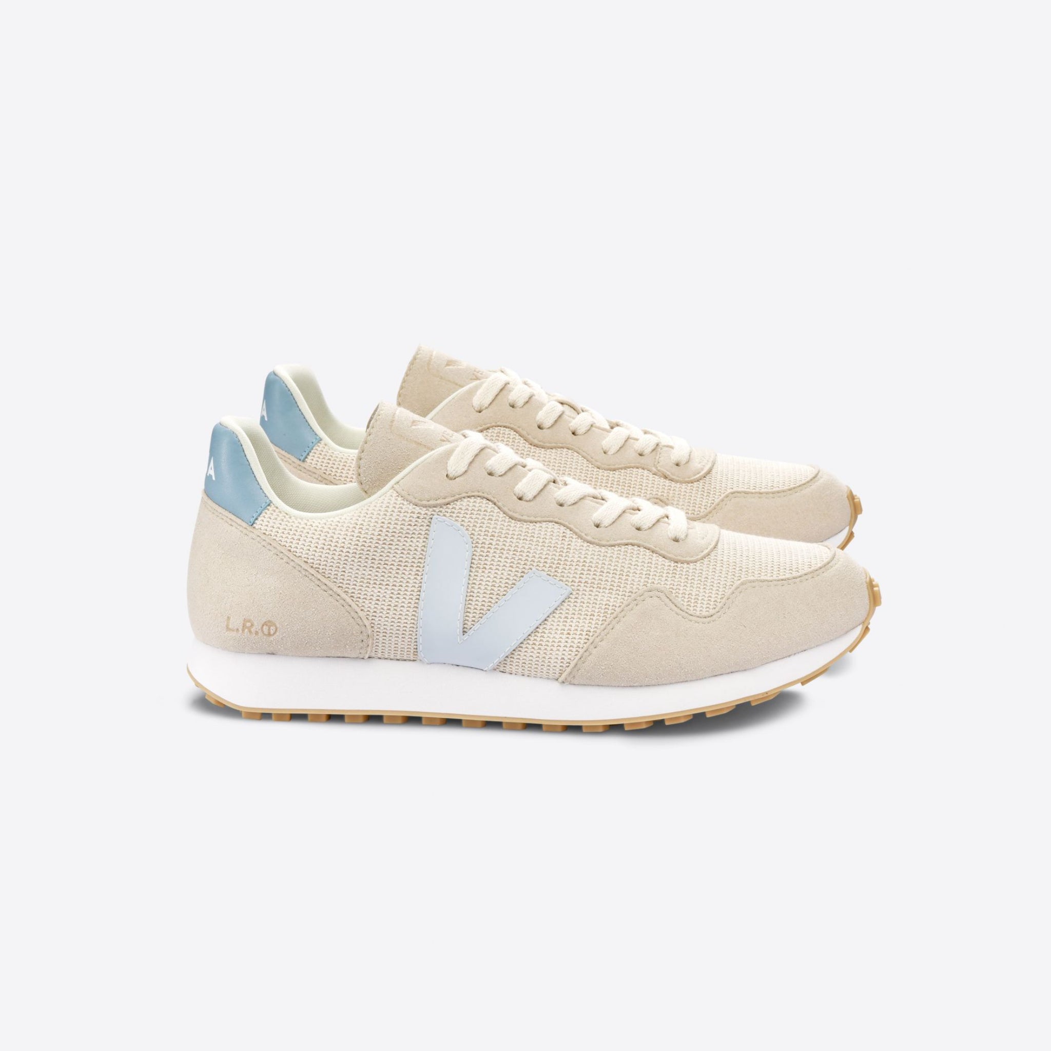Beiges Sneakerpaar mit hellblauen Details und seitlichem "V"-Logo auf weißem Hintergrund.