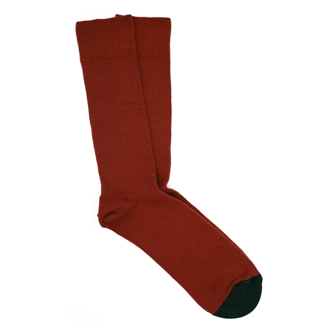 Ein Paar lange, rote Socken mit dunkelgrünen Zehenkappen, flach auf weißem Hintergrund.
