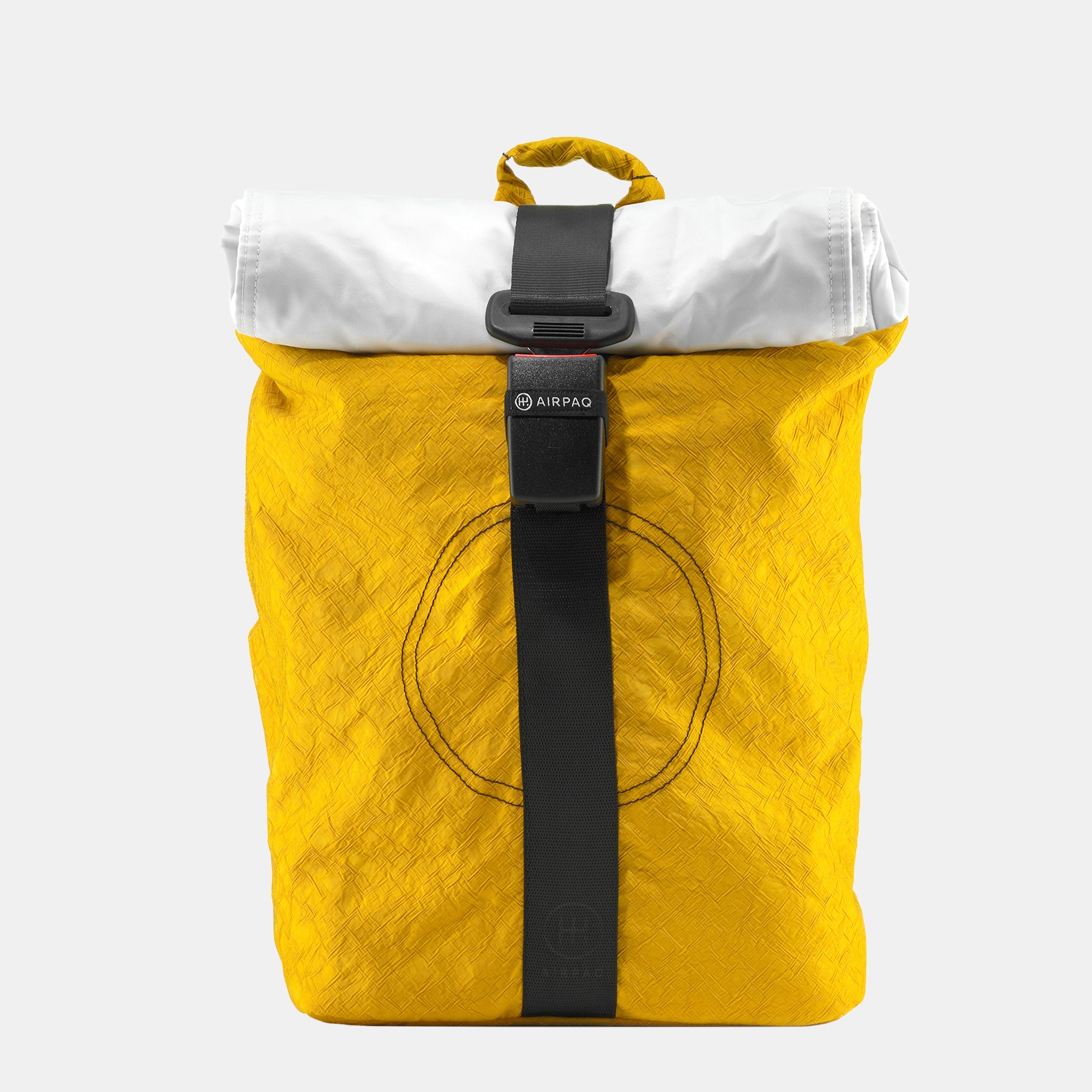 Ein leuchtend gelber Rolltop-Rucksack mit weißer Verschlussklappe, schwarzem Mittelriemen und Schnalle sowie einem kreisförmigen, genähten Muster auf der Vorderseite, das vor einem schlichten hellgrauen Hintergrund steht.