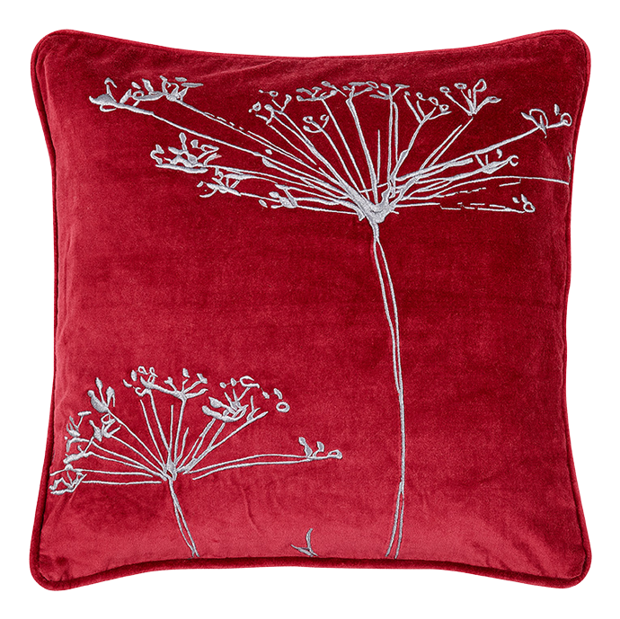 Rotes Kissen mit aufgesticktem, weißen Pflanzenmuster, das an Blumen oder Blüten erinnert.