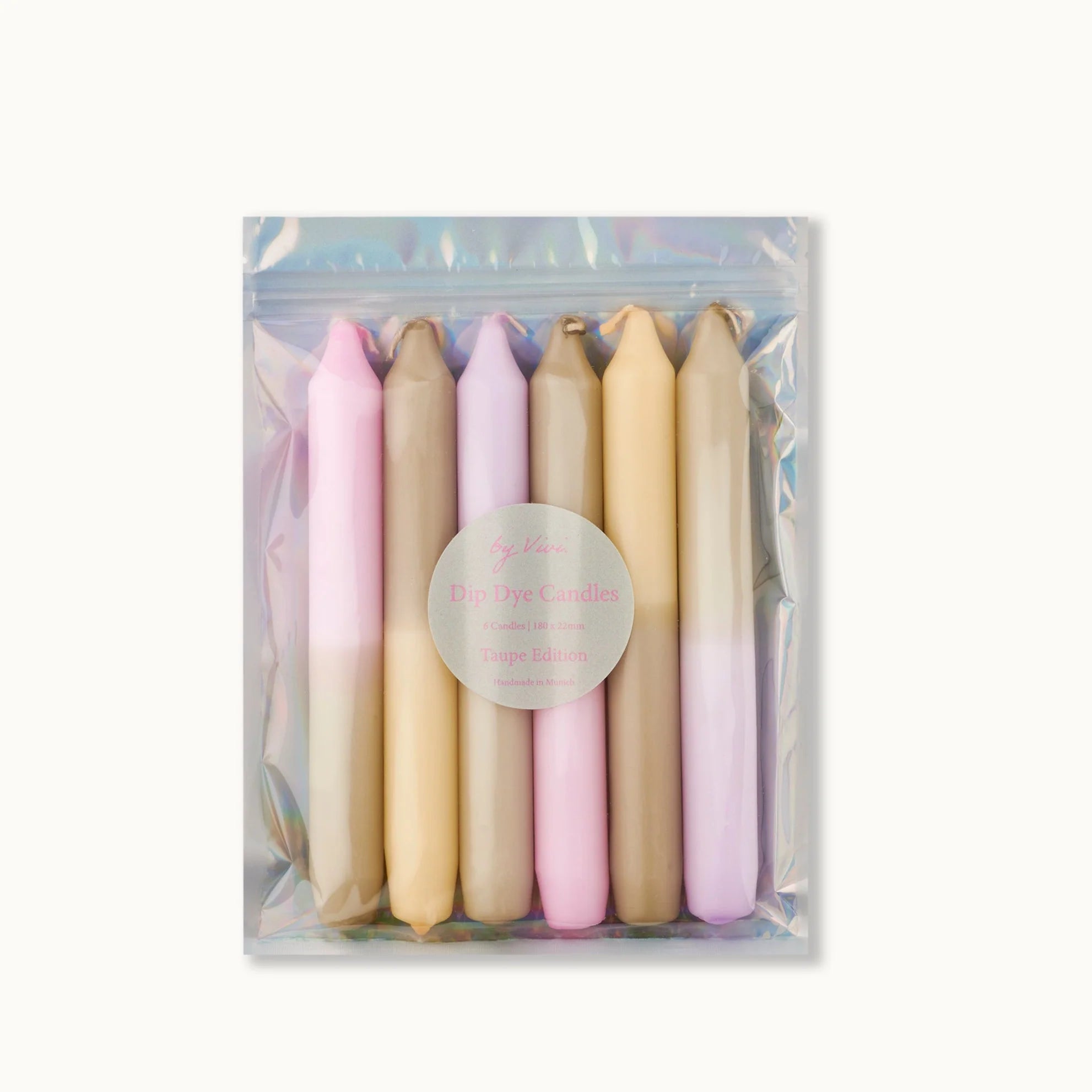 Ein Set von sechs Dip-Dye-Kerzen in den Farben Pastellrosa, Beige und Taupe, verpackt in einem klaren, schillernden, wiederverschließbaren Beutel mit einem runden Etikett mit der Aufschrift "Dip Dye Candles Taupe Edition".