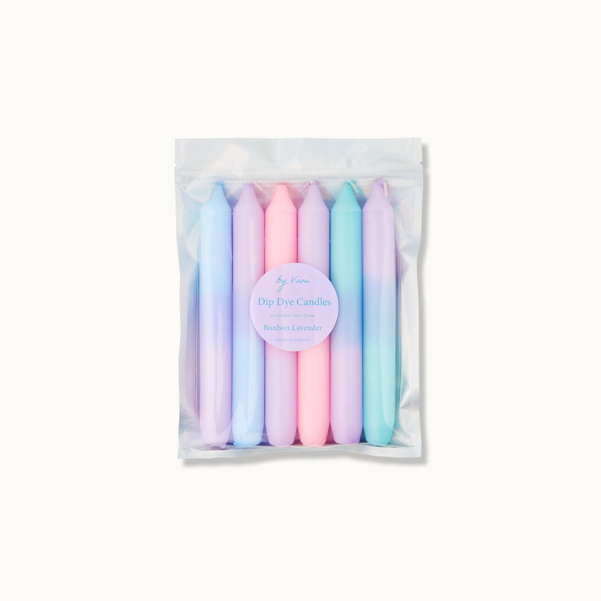 Ein durchsichtiger Plastikbeutel enthält sechs pastellfarbene Dip-Dye-Kerzen in Rosa-, Blau- und Lavendeltönen. Auf der Vorderseite befindet sich ein rundes Etikett mit der Aufschrift "Dip Dye Candles" und darunter der Duft "Bamboo Lavender".
