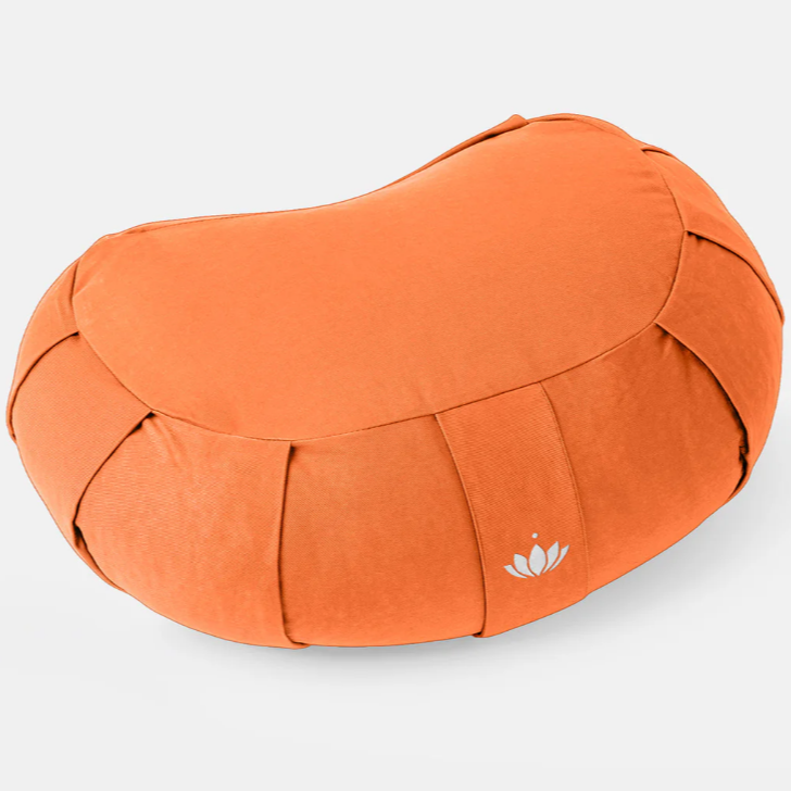 Orangeförmiges, orangefarbenes Kissen mit Stoffnähten und einem stilisierten Lotus-Logo an der Seite auf weißem Hintergrund.