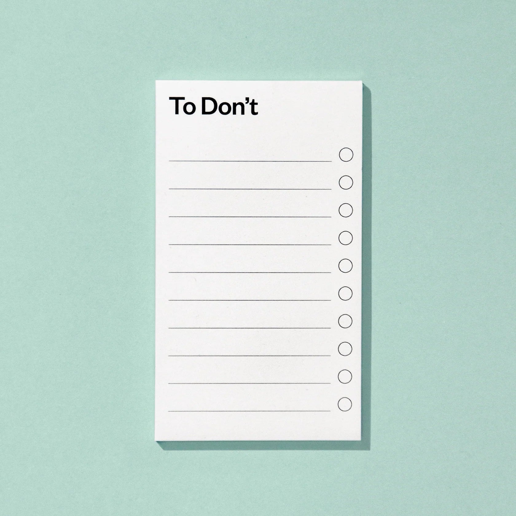 Ein Notizblock mit dem Titel To Dont mit leeren Zeilen und Kontrollkästchen auf einem hellblauen Hintergrund.