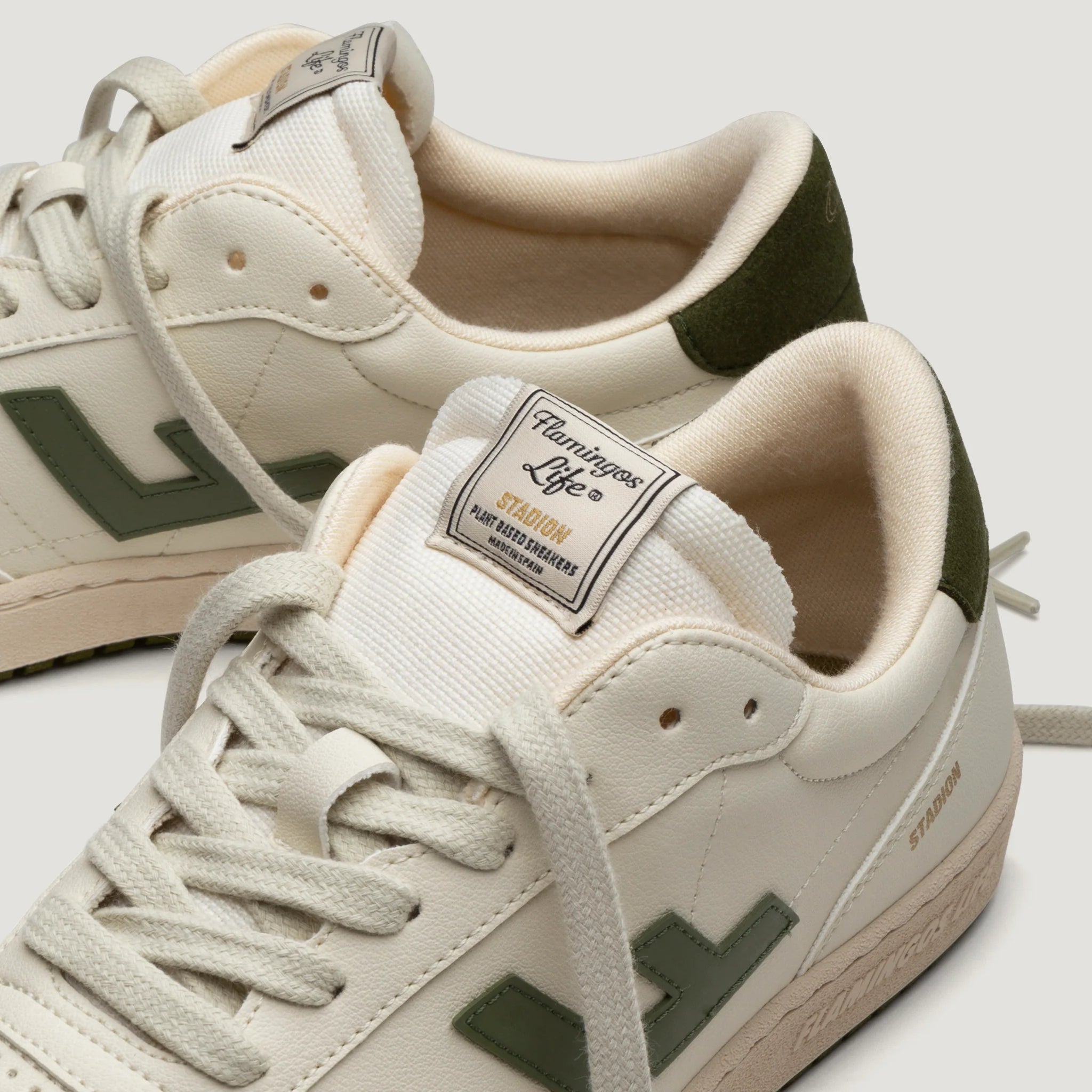 Weiße Sneakers mit grünen Akzenten und Label "Flamingos Life".
