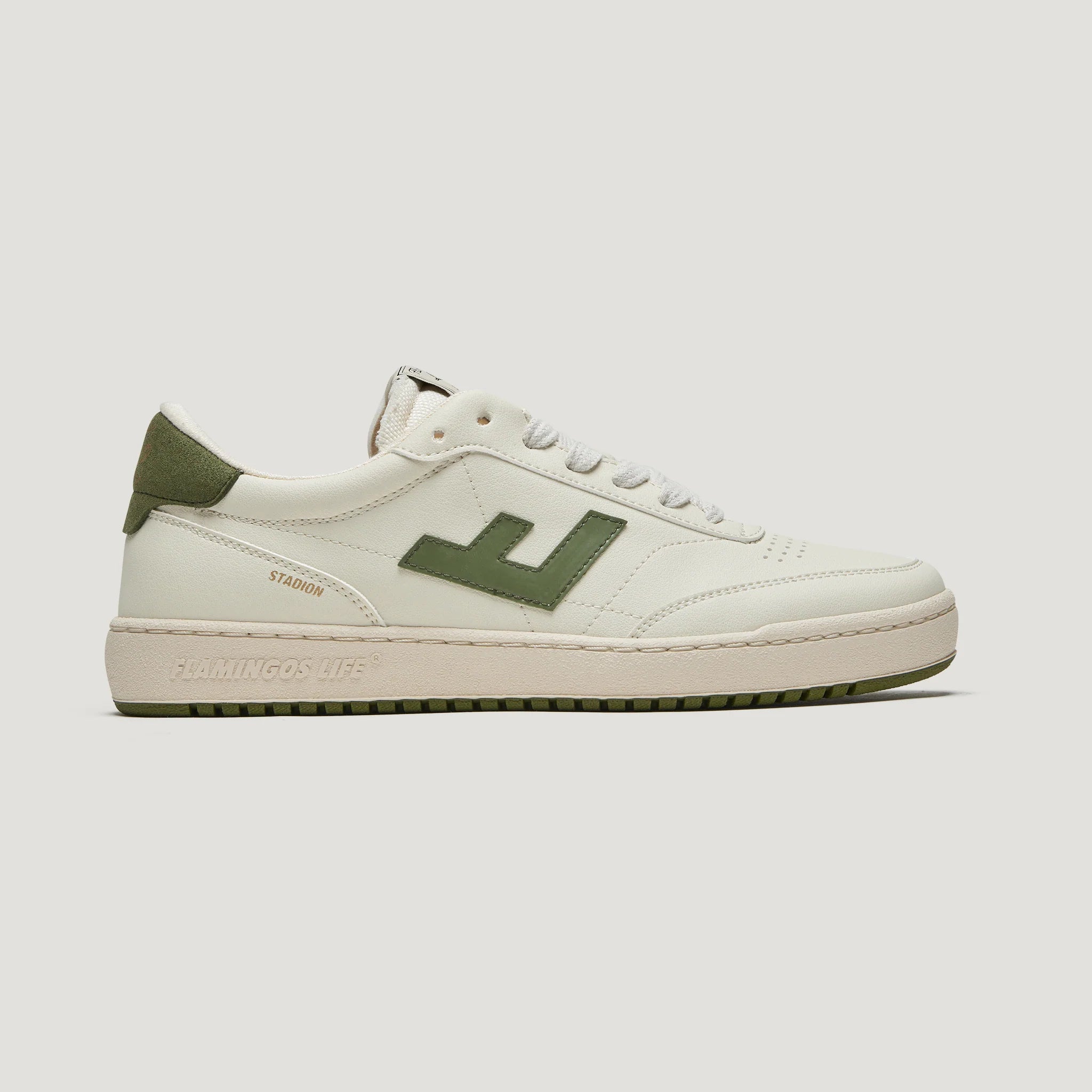 Weiße und grüne Sneaker mit Logo-Detail und der Aufschrift "Flamingos Life" an der Sole, Seitenansicht.