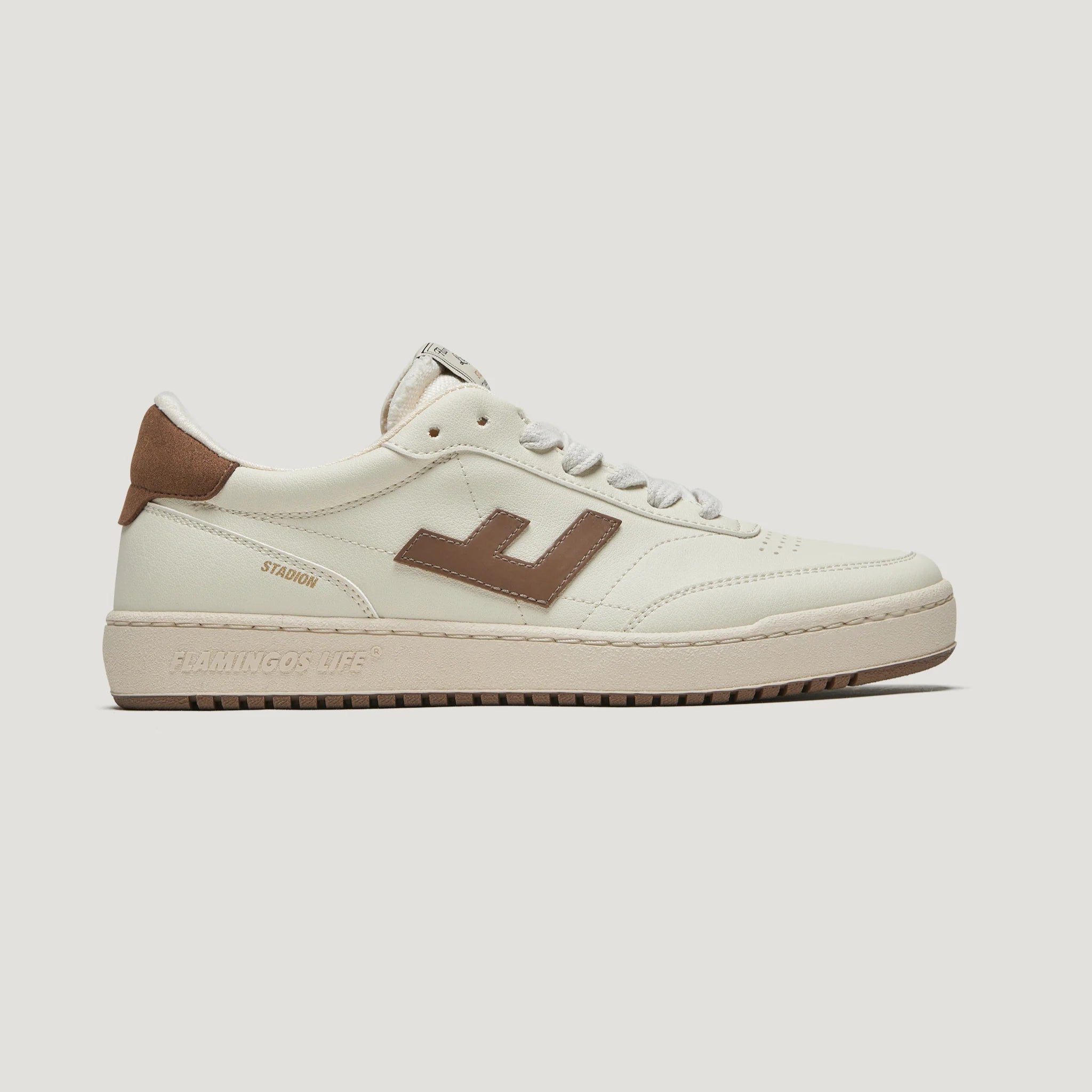 Weißer Sneaker mit braunen Details und einer braunen Sohle, seitlich abgebildet, auf hellem Hintergrund.