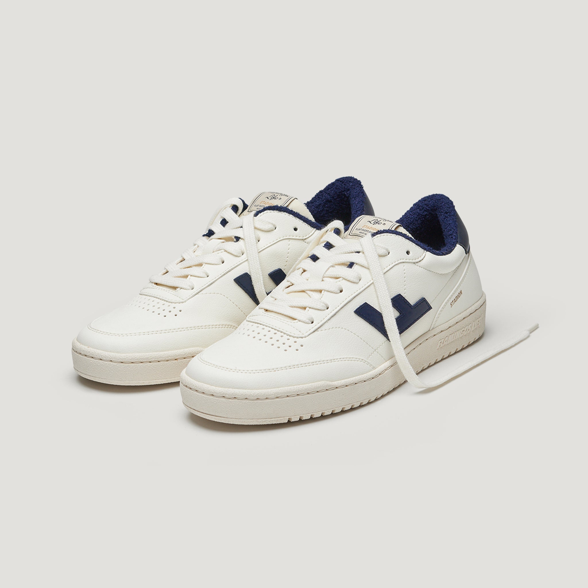 Weiße Sneakers mit blauen Details und flauschigem Futter, beide Schuhe nach vorne gerichtet, auf hellem Hintergrund.
