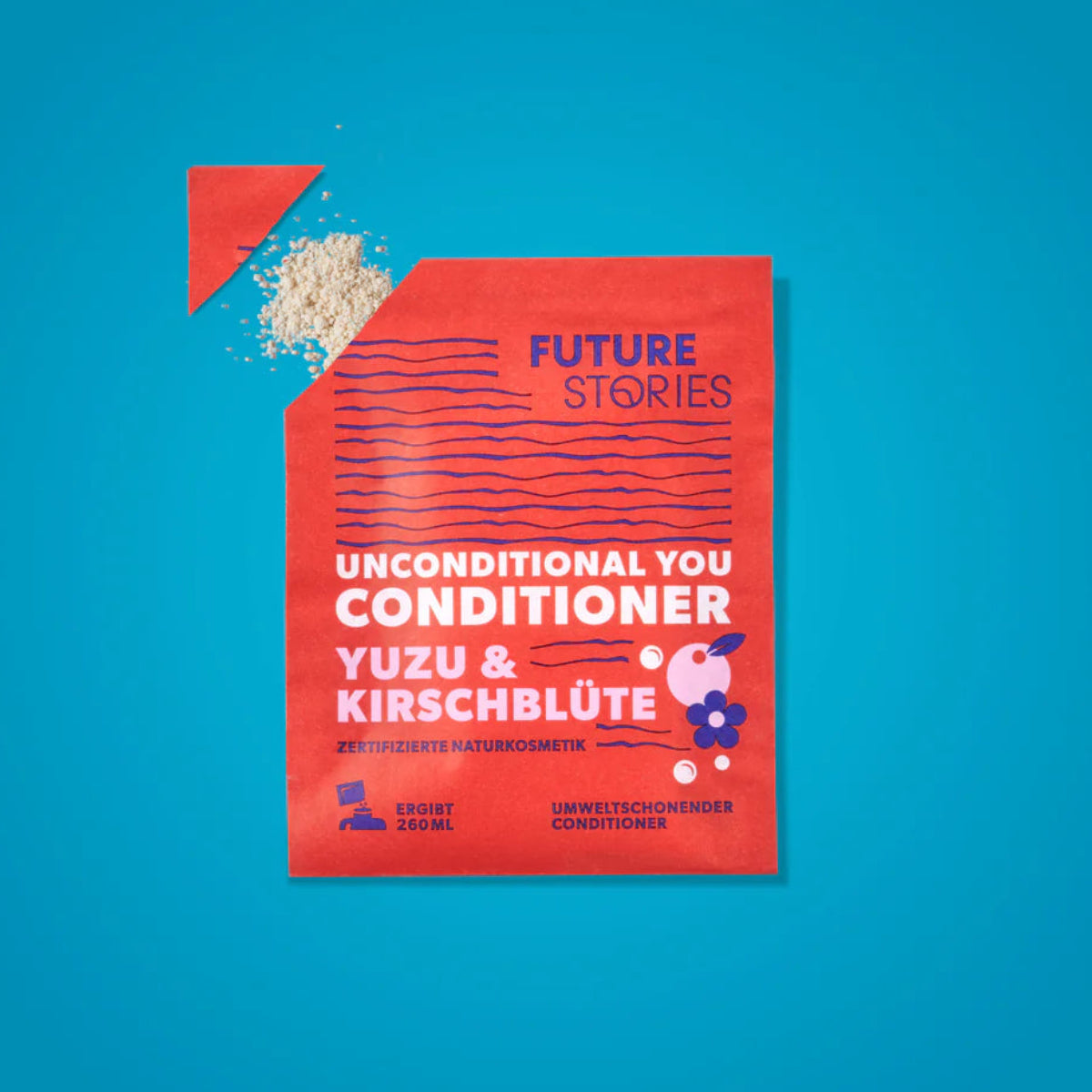 Ein roter Beutel Future Stories Unconditional You Conditioner (Yuzu & Kirschblüte) liegt auf blauem Hintergrund, wobei ein Teil des körnigen Inhalts aus der aufgerissenen oberen linken Ecke herausläuft.
