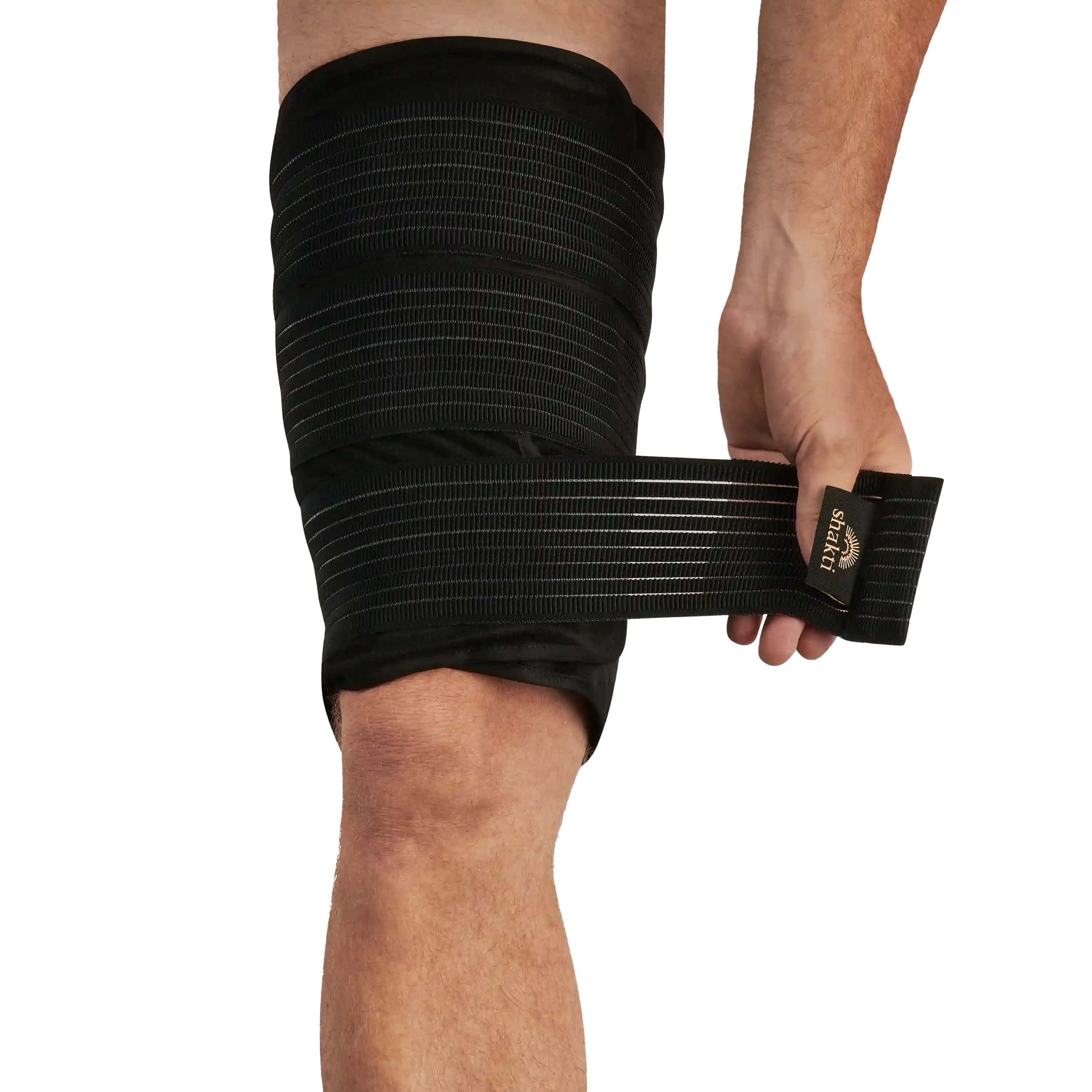 Eine Person wickelt sich eine schwarze elastische Bandage um den Oberschenkel und fixiert sie mit einer Hand.