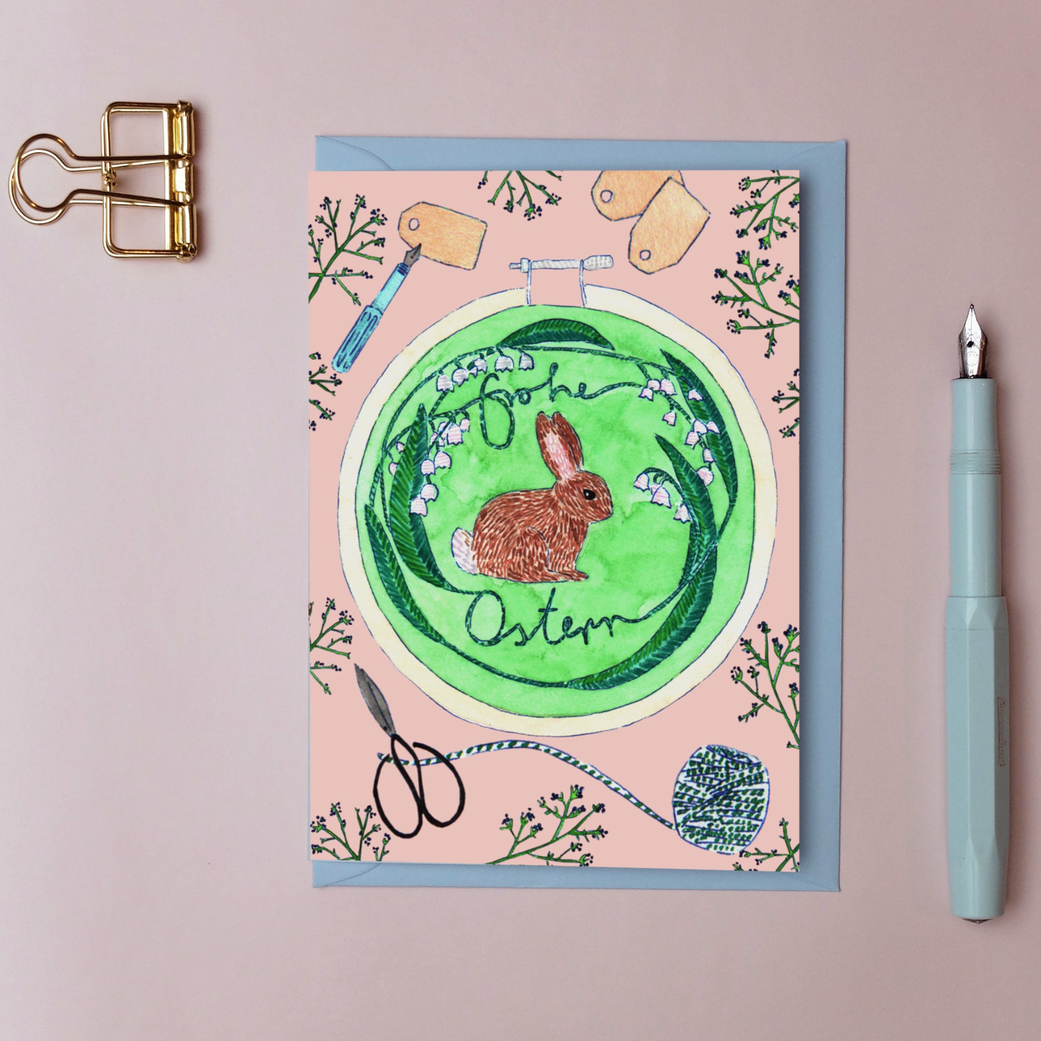 Osterkarte mit einem gezeichneten Hasen und "Frohe Ostern" in der Mitte, umgeben von floralen Mustern.