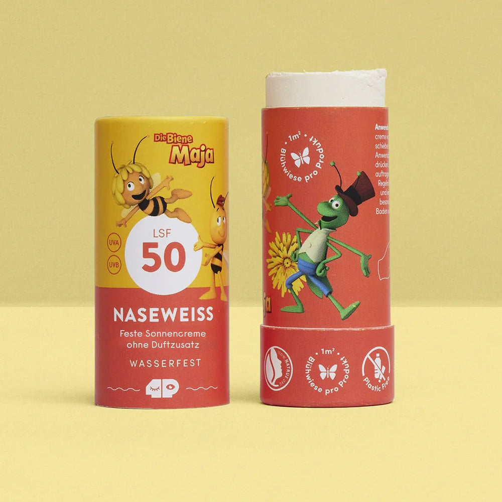 Zwei bunte Sonnenschutzstifte sind vor einem hellgelben Hintergrund abgebildet. Der linke Stick zeigt die Figur der Biene Maja mit LSF 50 und NASEWEISS auf dem Etikett. Der rechte Stick zeigt eine grüne Grashüpfer-Cartoonfigur.