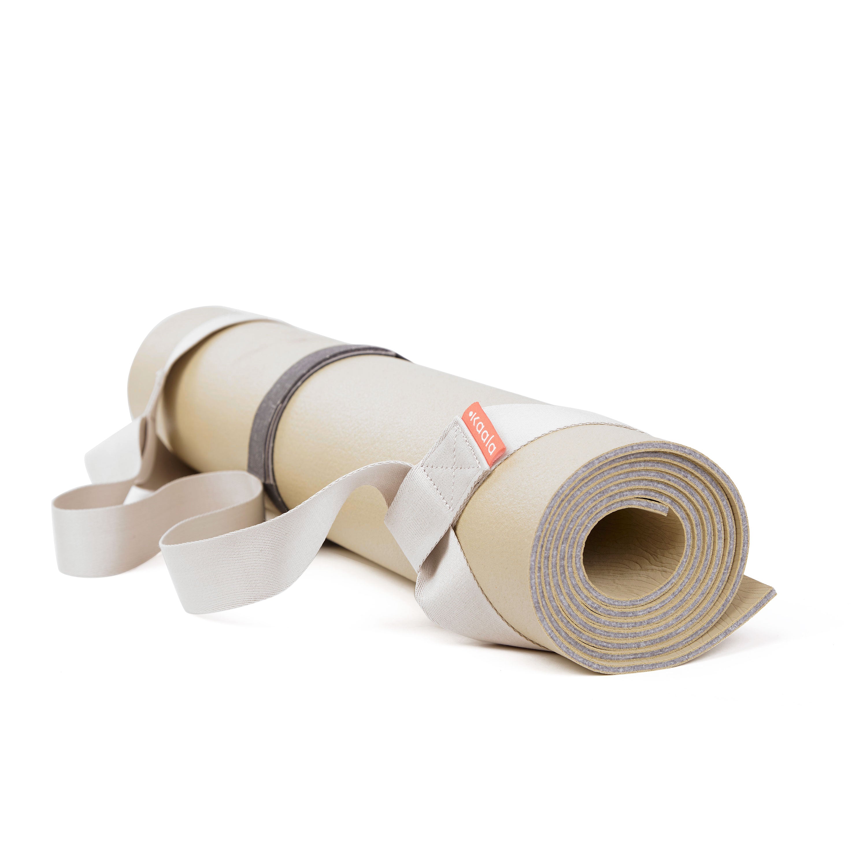 Beige Yogamatte mit grauen und weißen Riemen, aufgerollt und bereit für den Transport auf weißem Hintergrund.
