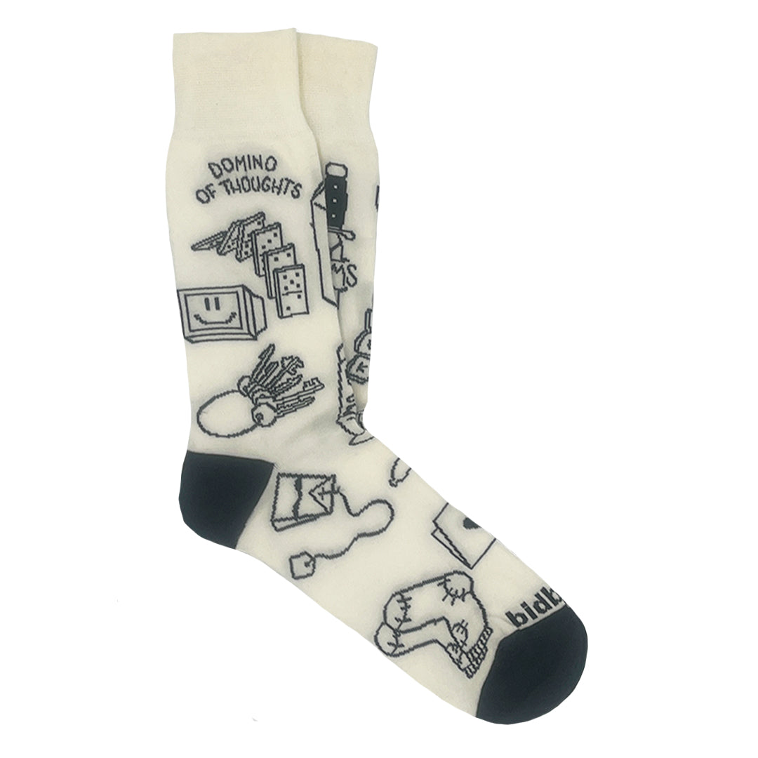 Cremefarbene Socken mit schwarzer Spitze und Ferse, auf denen Zeichnungen im Doodle-Stil zu sehen sind, darunter Dominosteine, Schlüssel, Hände, Malutensilien und der Schriftzug "DOMINO OF THOUGHTS" am oberen Rand.