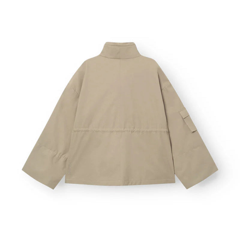 Eine beigefarbene, langärmelige Jacke mit hohem Kragen und lockerer Passform, von hinten gesehen. Die Jacke hat einen Saum in der Taille und eine Tasche mit Klappe an einem Ärmel.