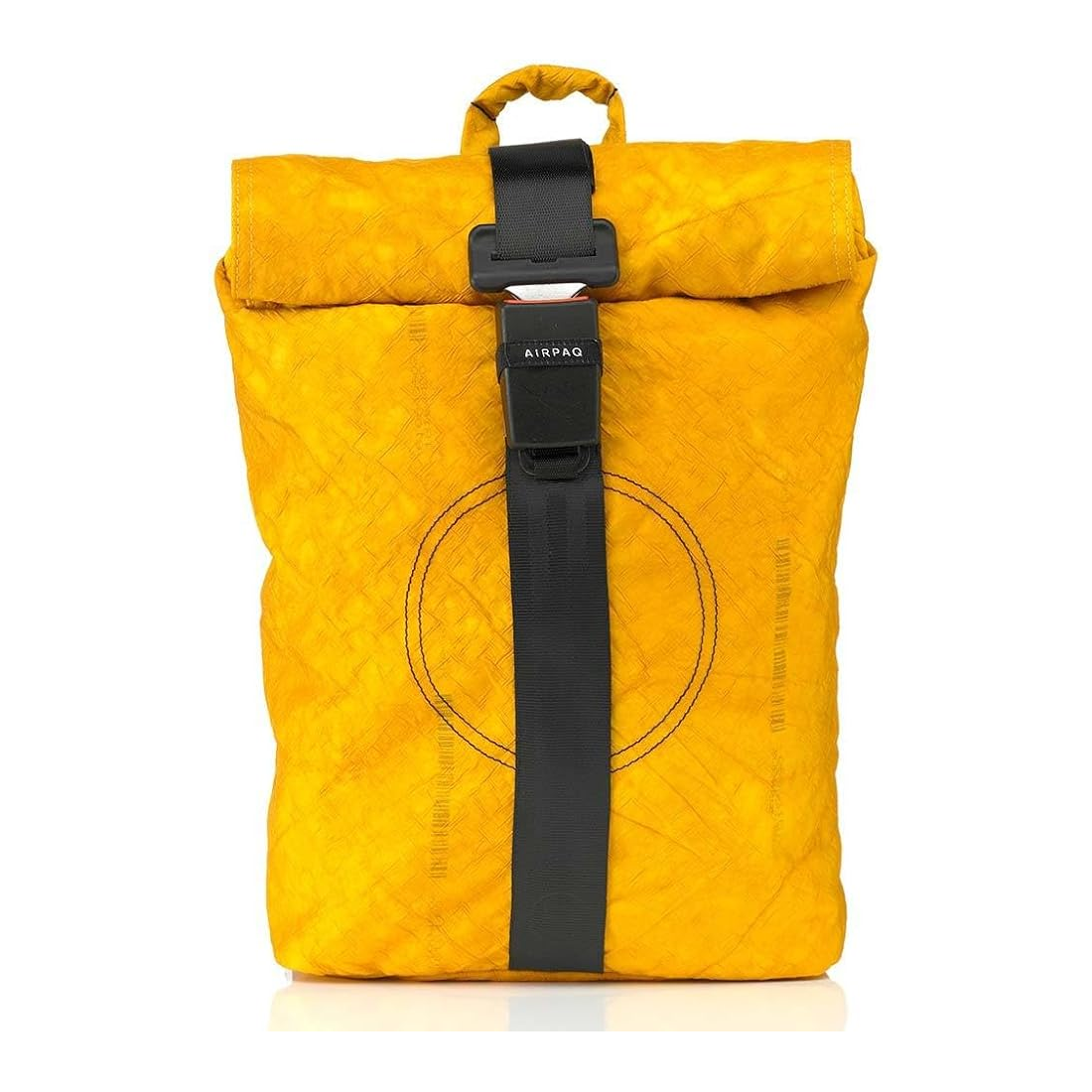 Ein leuchtend gelber Rucksack mit Rollverschluss, schwarzem Riemen in der Mitte und einem Griff an der Oberseite. Auf der Vorderseite ist ein kreisförmiges Muster aufgenäht. Auf dem Etikett am Gurt steht AIRPAQ.