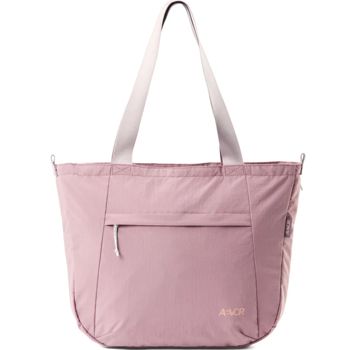 Eine hellrosa Tragetasche mit zwei Schulterriemen, einer Reißverschlusstasche auf der Vorderseite und dem Markennamen AVOR in goldener Schrift in der unteren rechten Ecke.