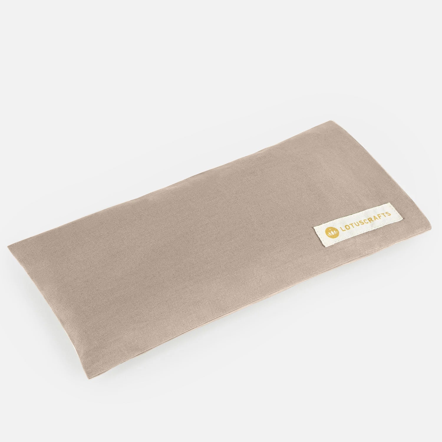 Ein rechteckiges beiges Stoff-Augenkissen mit einem kleinen aufgenähten Etikett mit der Aufschrift LOSCRAFTS auf einem schlichten weißen Hintergrund.