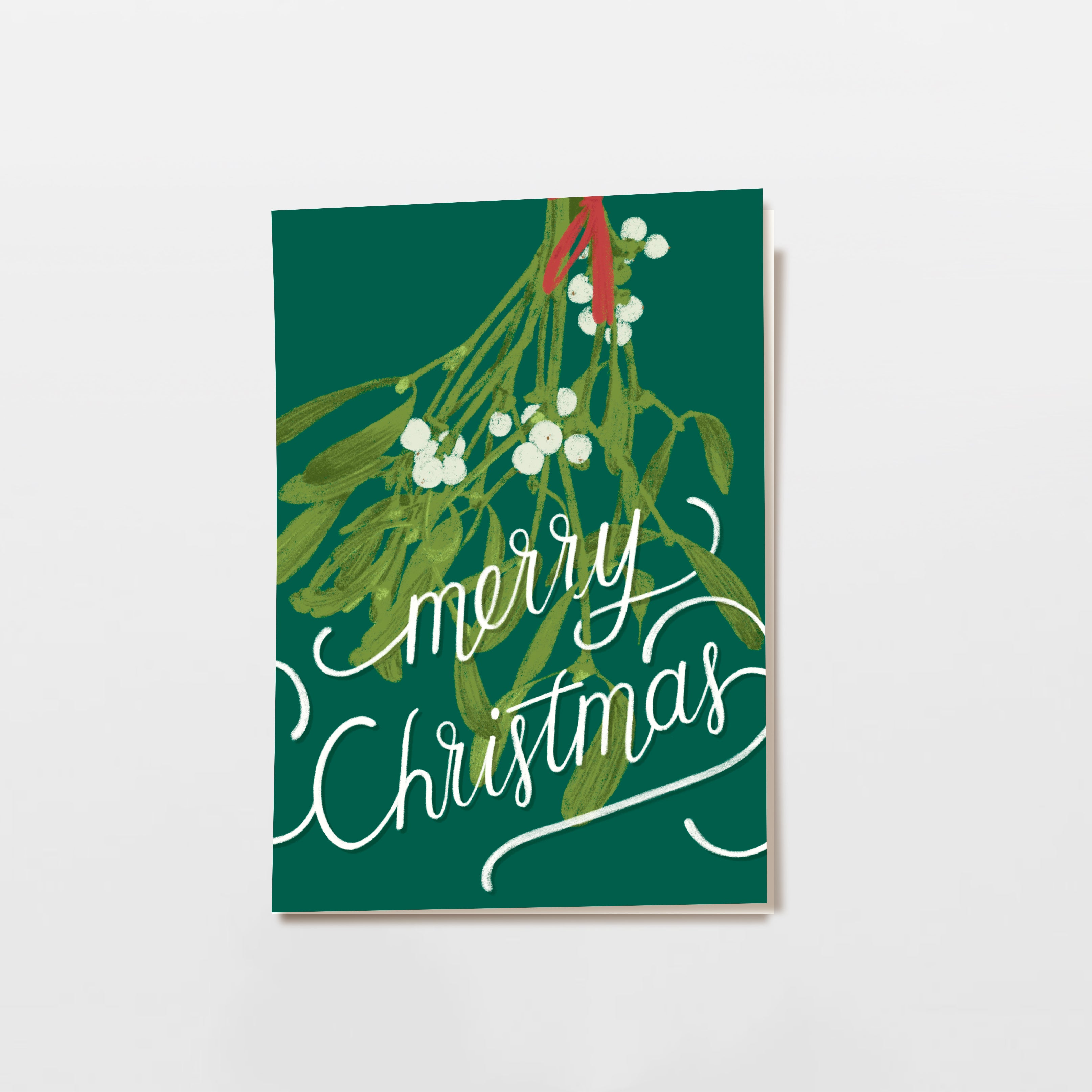 Eine festliche Karte mit grünem Mistelzweig und weißen Beeren auf dunkelgrünem Hintergrund. Auf der Vorderseite stehen in eleganter weißer Schrift die Worte "Frohe Weihnachten".