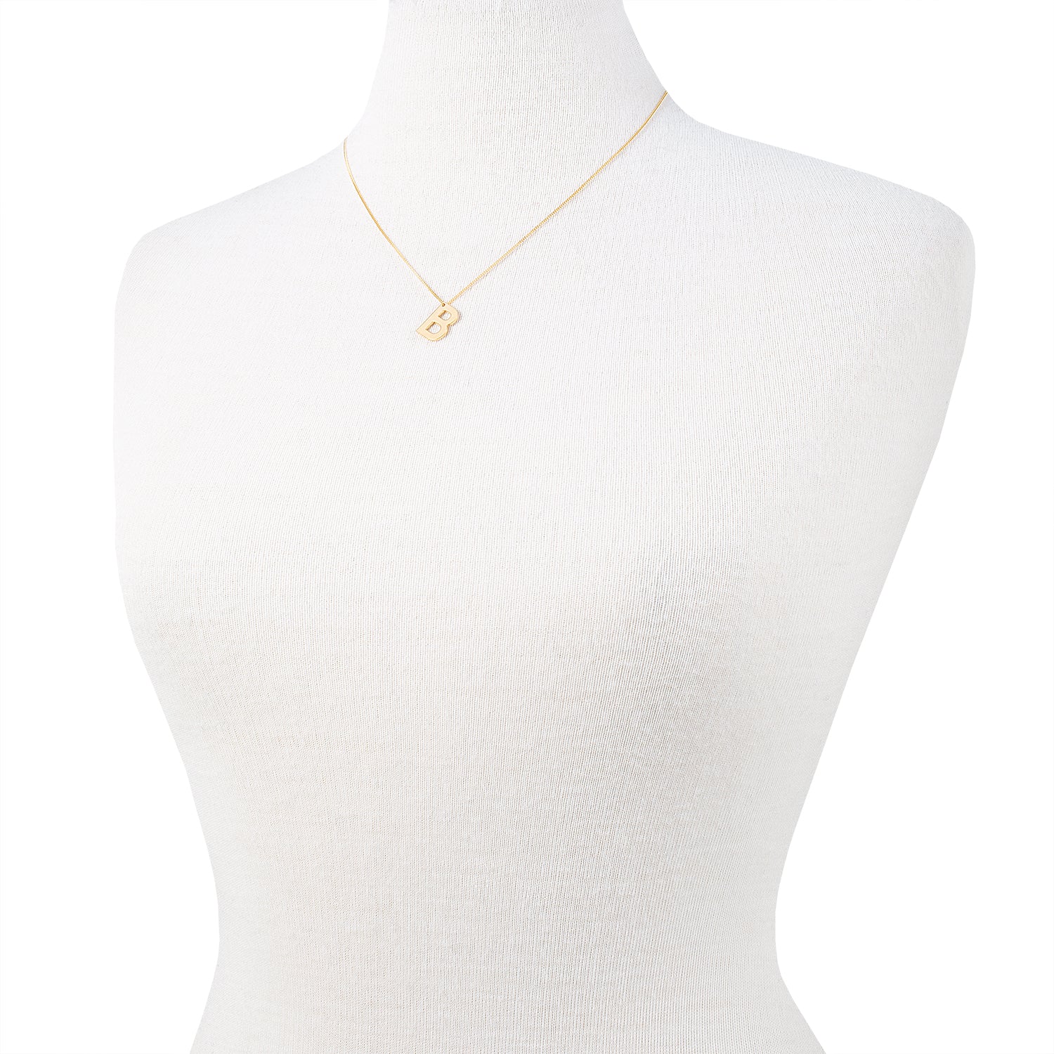 Eine goldene Halskette mit einem Anhänger mit dem Buchstaben B, der auf einer weißen Schaufensterpuppe angebracht ist.