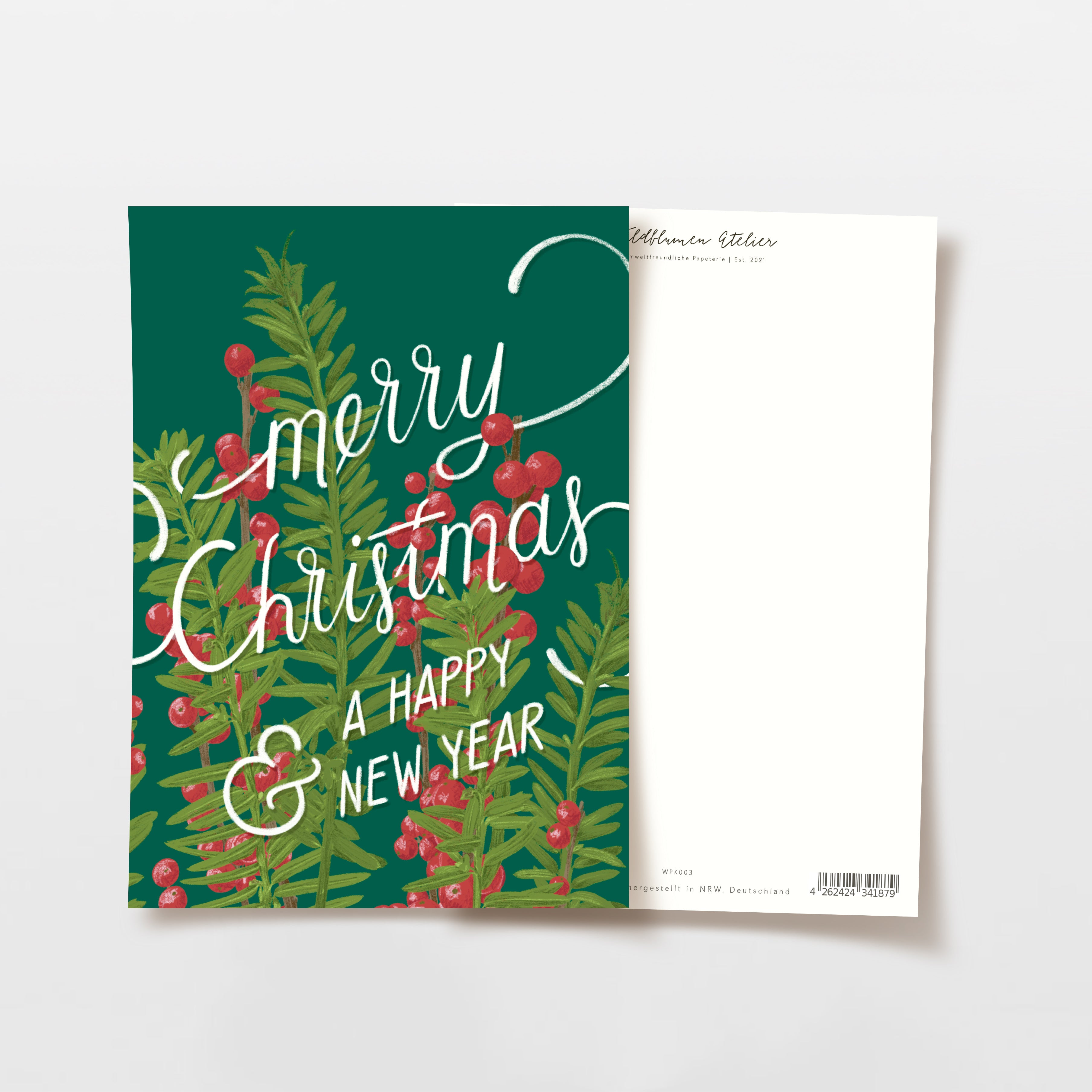 Eine festliche Grußkarte mit grünen Tannenzweigen und roten Beeren, auf deren Vorderseite in weißer Schrift die handschriftliche Botschaft Frohe Weihnachten und ein gutes neues Jahr steht. Die Rückseite der Karte ist größtenteils leer.