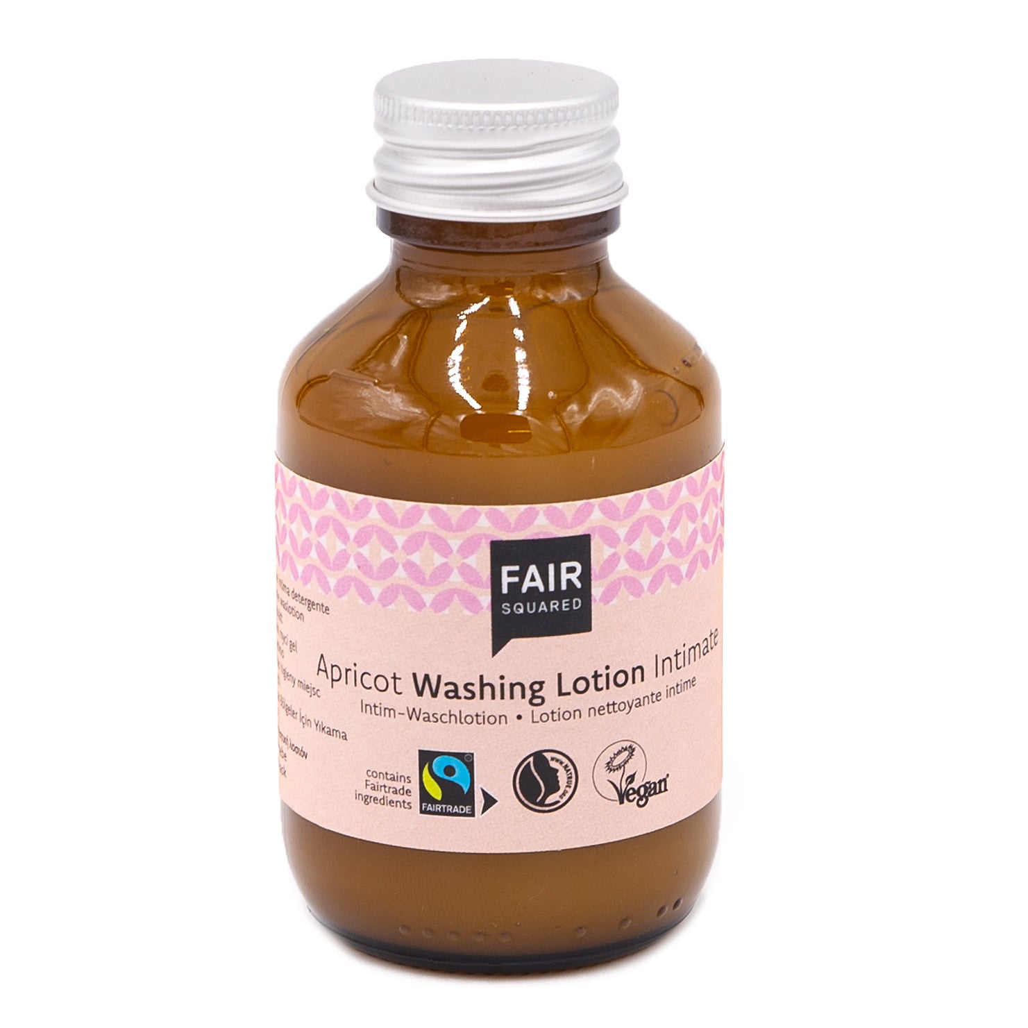 Eine braune Glasflasche mit einer silbernen Kappe mit der Aufschrift Fair Squared Apricot Washing Lotion Intimate. Das Etikett enthält Symbole für Fairtrade, vegane und natürliche Inhaltsstoffe auf einem weißen Hintergrund mit rosa Mustern.