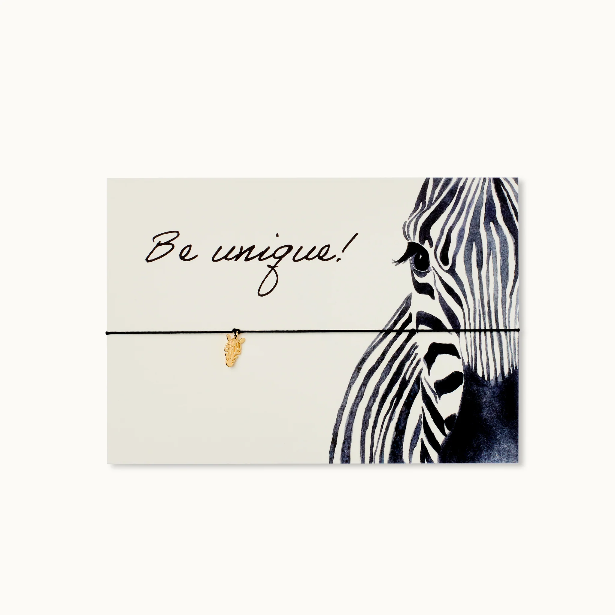 Kartendesign mit Zebramuster und kleinem goldenen Blattanhänger, Text: "Be unique!".