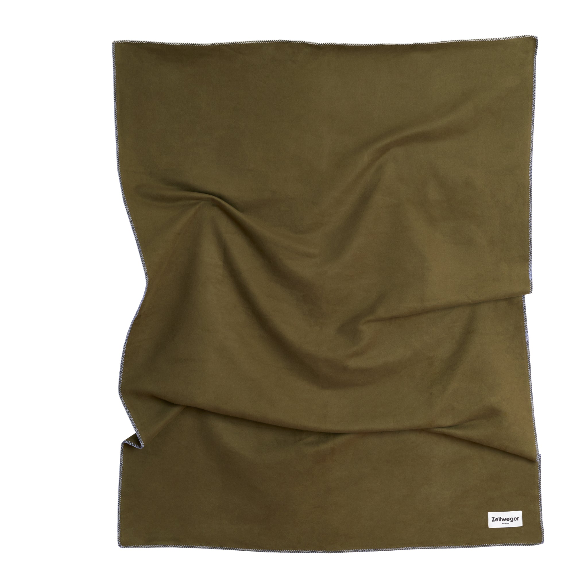 Braune Decke mit weicher Textur, leicht gefaltet, auf weißem Hintergrund. Unten rechts ist ein kleines Etikett sichtbar.