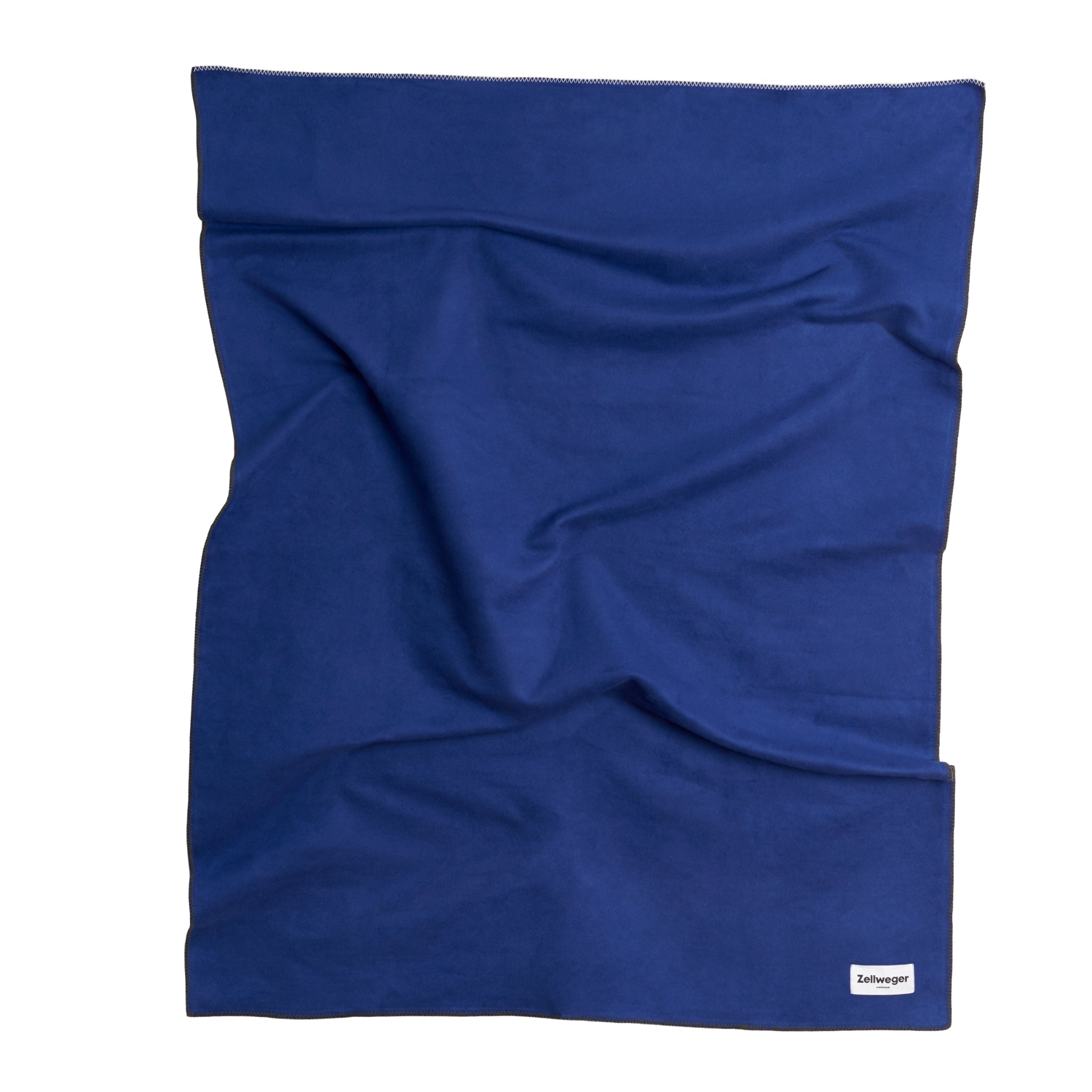 Blaue, gefaltete Decke mit einem kleinen weißen Etikett in der unteren rechten Ecke.