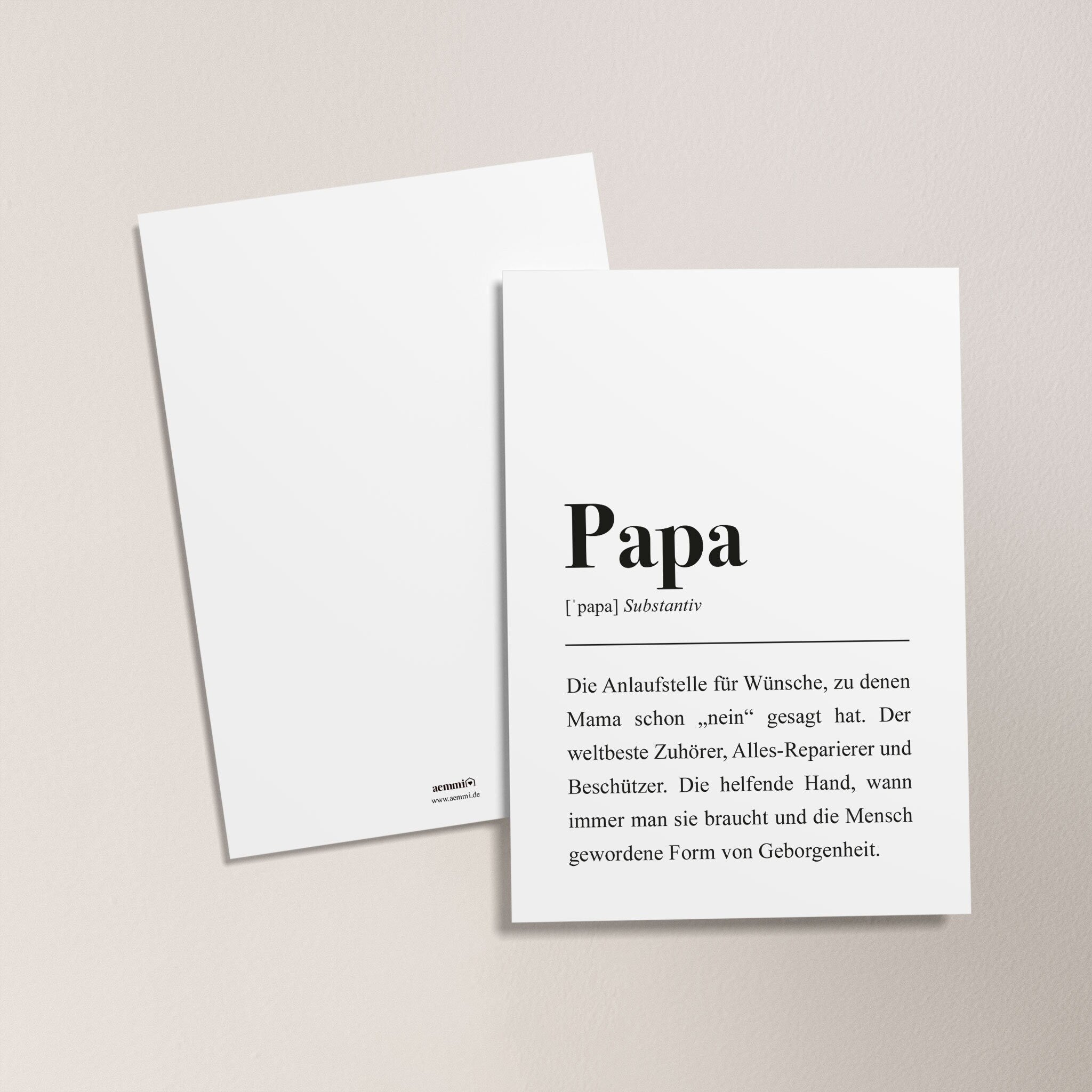Zwei weiße Karten auf einer Oberfläche, eine mit der Definition von "Papa" als Substantiv und liebevoller Beschreibung.